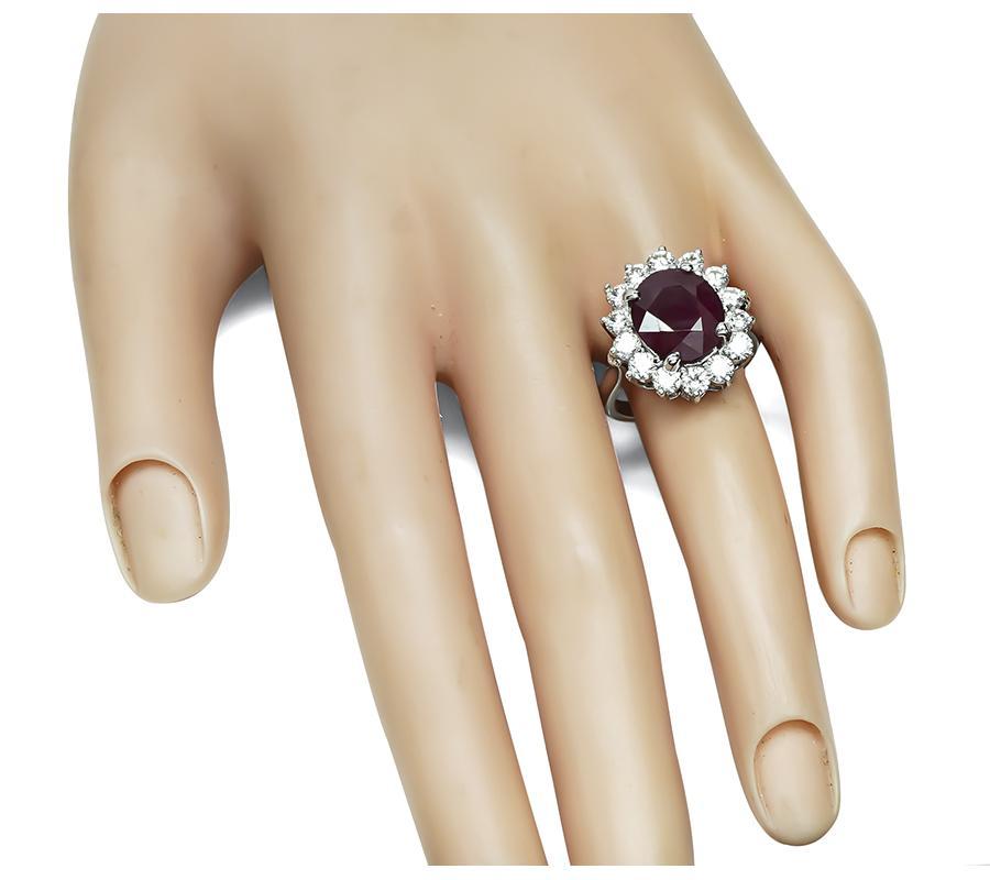 This is a stunning platinum engagement ring. The ring is centered with lovely oval cut ruby that weighs 5.41ct. The ruby is accentuated by sparkling round cut diamonds that weigh approximately 1.80ct. The color of the diamonds is H-I with VS
