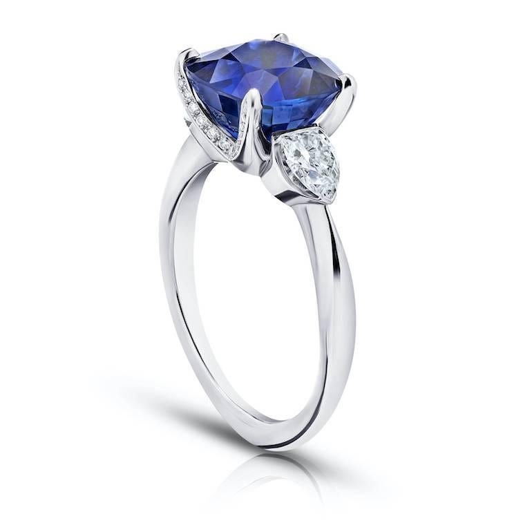 5.42 carat cushion blue sapphire with 2 shield cut diamonds .59 carats and 24 round diamonds .07 carats set in a hand made platinum ring.
