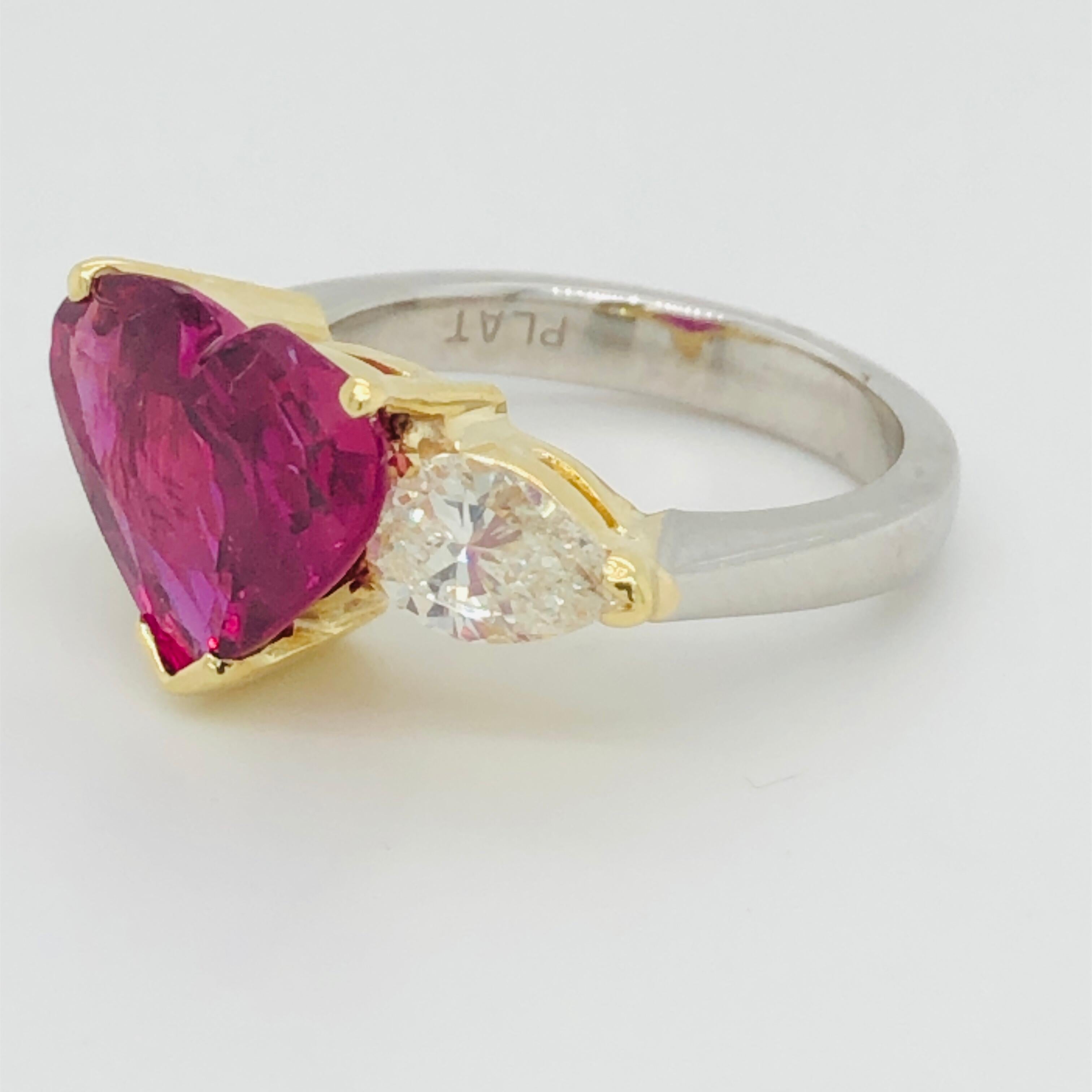Offered here is a gorgeous heart shape ruby set in platinum and 18kt yellow gold ring with two pear shape diamonds. 
Ruby: 5.43 carat Natural heart shape ruby, natural corundum, transparent purplish red 
AGL cert# 1111899 measurements 10.67 x 13.53