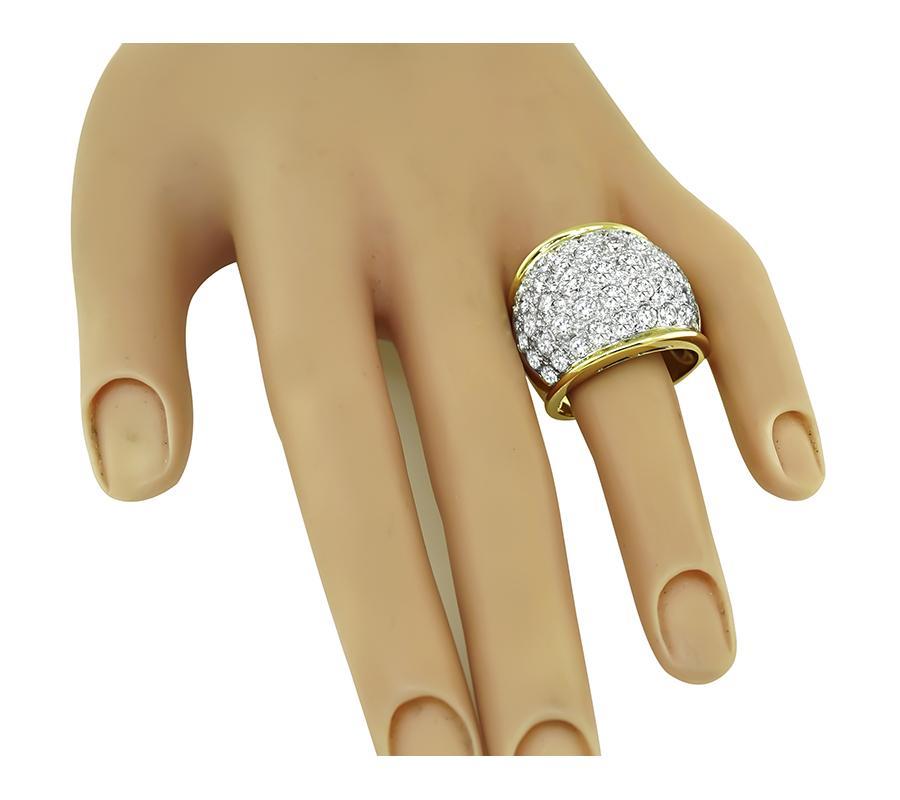 This is an elegant 18k yellow and white gold ring. The ring is set with sparkling round cut diamonds that weigh approximately 5.43ct. The color of the diamonds is G with VS clarity. The ring has a tapering width from 8mm to 22mm. The ring is stamped