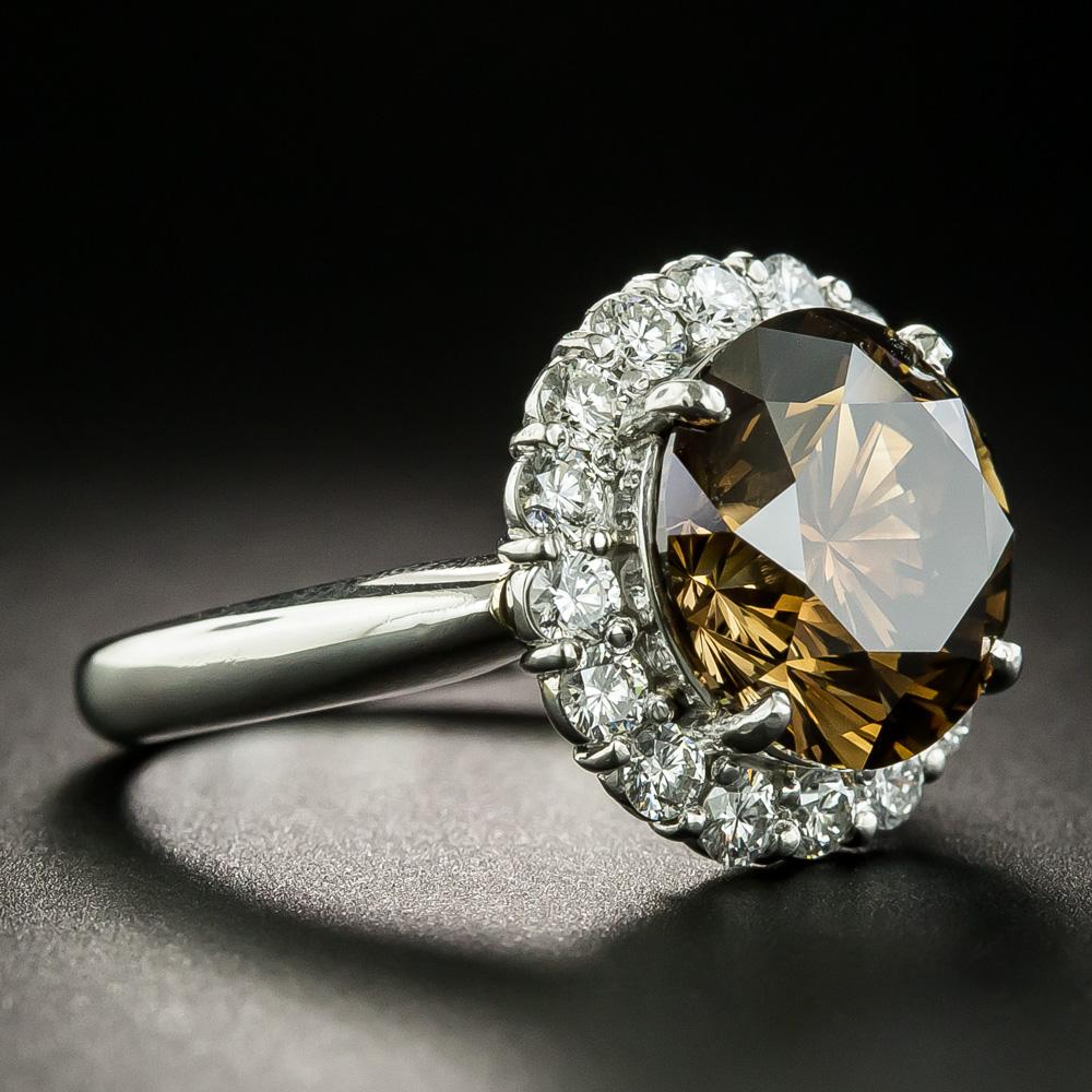An intriguing, entrancing, and enchanting diamond: tipping the scale at 5.45 carats, this gorgeous modern round brilliant-cut diamond is saturated with a sparkling cognac brown coloration sparked with a touch of orange. The exotic stone scintillates