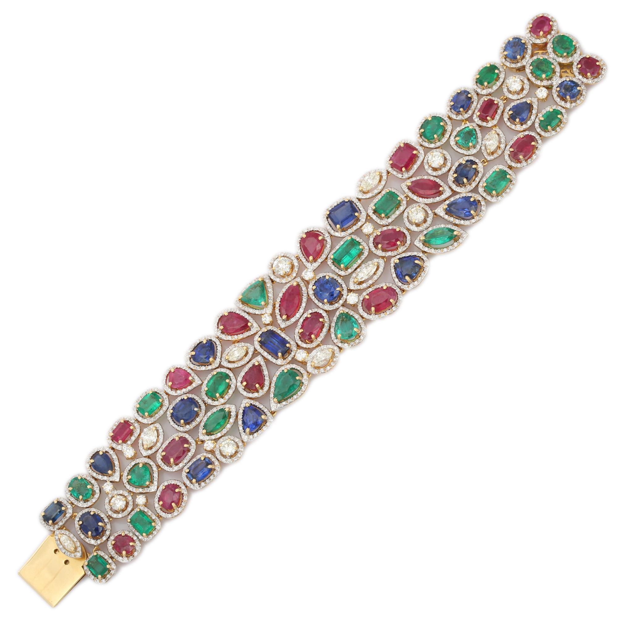 Faites une impression éblouissante avec ce luxueux bracelet de pierres précieuses multicolores fabriqué à la main en or jaune massif 18K. Ornée de 55 émeraudes, rubis et saphirs naturels pesant au total 54,5 carats, cette pièce exquise est rehaussée