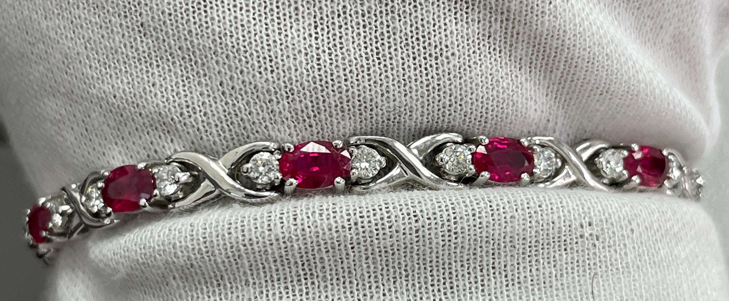This bracelet holds STUNNING 5x3 oval vibrant rubies in a 14K white gold bracelet holding 1.40 carats of white diamonds