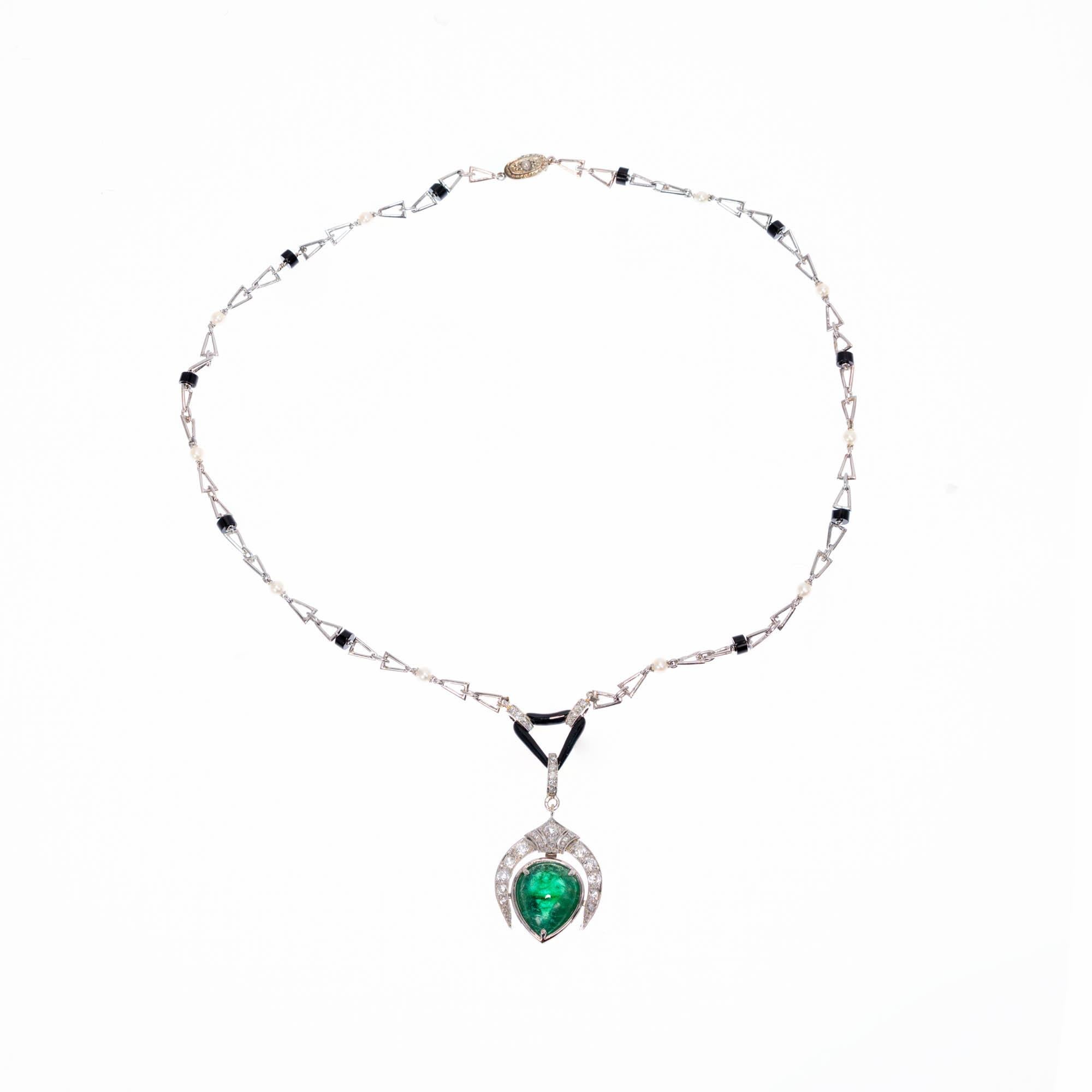 Platinum emerald, diamond, pearl and onyx necklace. Pear shaped double cabochon green emerald is bezel and prong set with an Art Deco style horse shoe top adorned with wound old European diamonds and rose cut diamonds. Pendant is attached to a