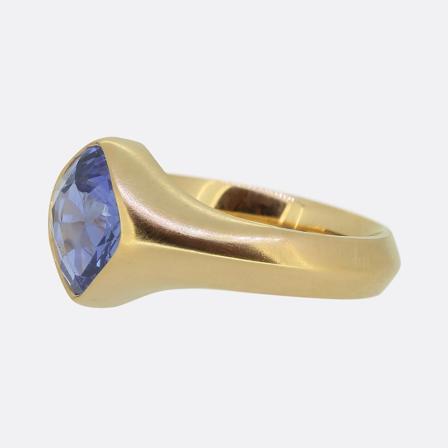 Nous avons ici une superbe bague solitaire en saphir. Cette pièce unique a été réalisée en or jaune 18 carats teinté rose et comporte un saphir antique carré de taille coussin, serti sans discontinuité au centre de la face. Cette pierre imposante