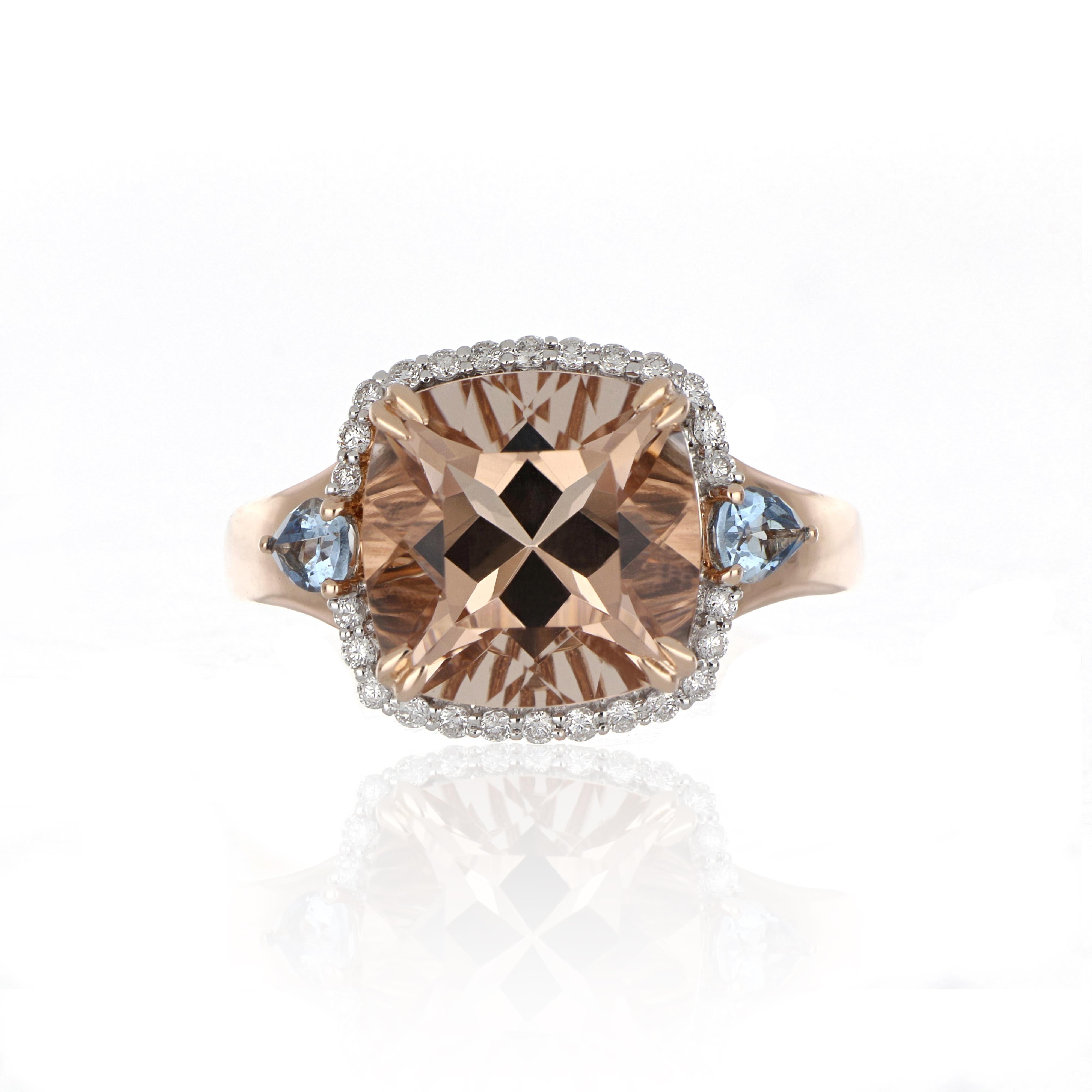 Elegant and exquisitely detailed three stone Cocktail 14K Ring, centre set with 5.19 Cts. Cushion Morganite surrounded by Diamonds, weighing approx. 0.22 cts. total carat weight accented on shoulder with Pear Shape 0.27 Cts. Aquamarines. Beautifully