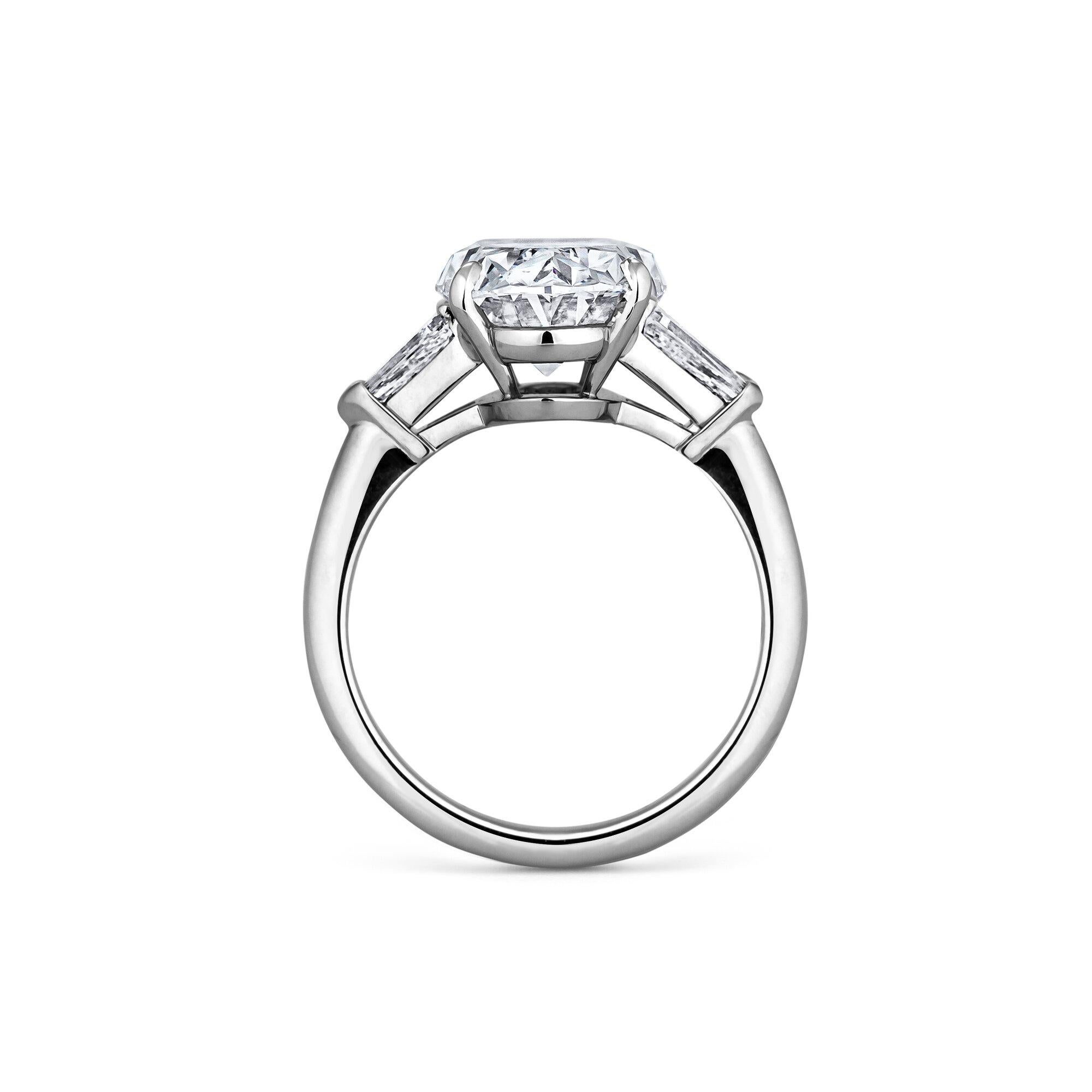 This sumptuous 5.47 cushion brilliant cut diamond engagement ring is as full and fiery as a gemstone can get.  Mounted in a handmade platinum setting with two diamond side bullets, this ring is simply extraordinary.  Center stone F color.  VS1