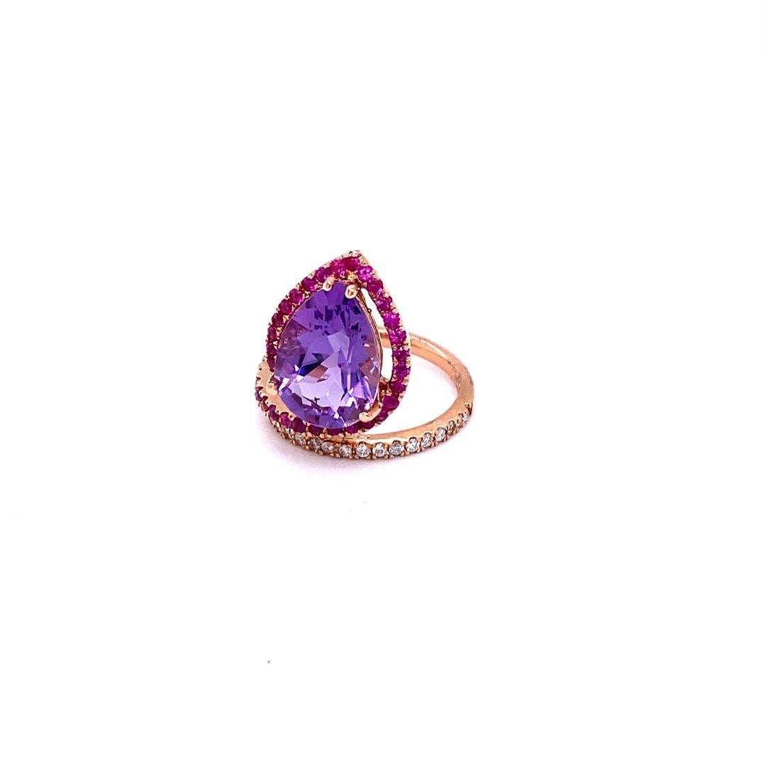 This ring has a Pear Cut Amethyst that weighs 4.63 Carats and is embellished with alternating 36 Pink Sapphires that weigh 0.65 Carats and 18 Round Cut Diamonds that weigh 0.21 Carats.  (Clarity: SI2, Color:F) 
The total carat weight of the ring is