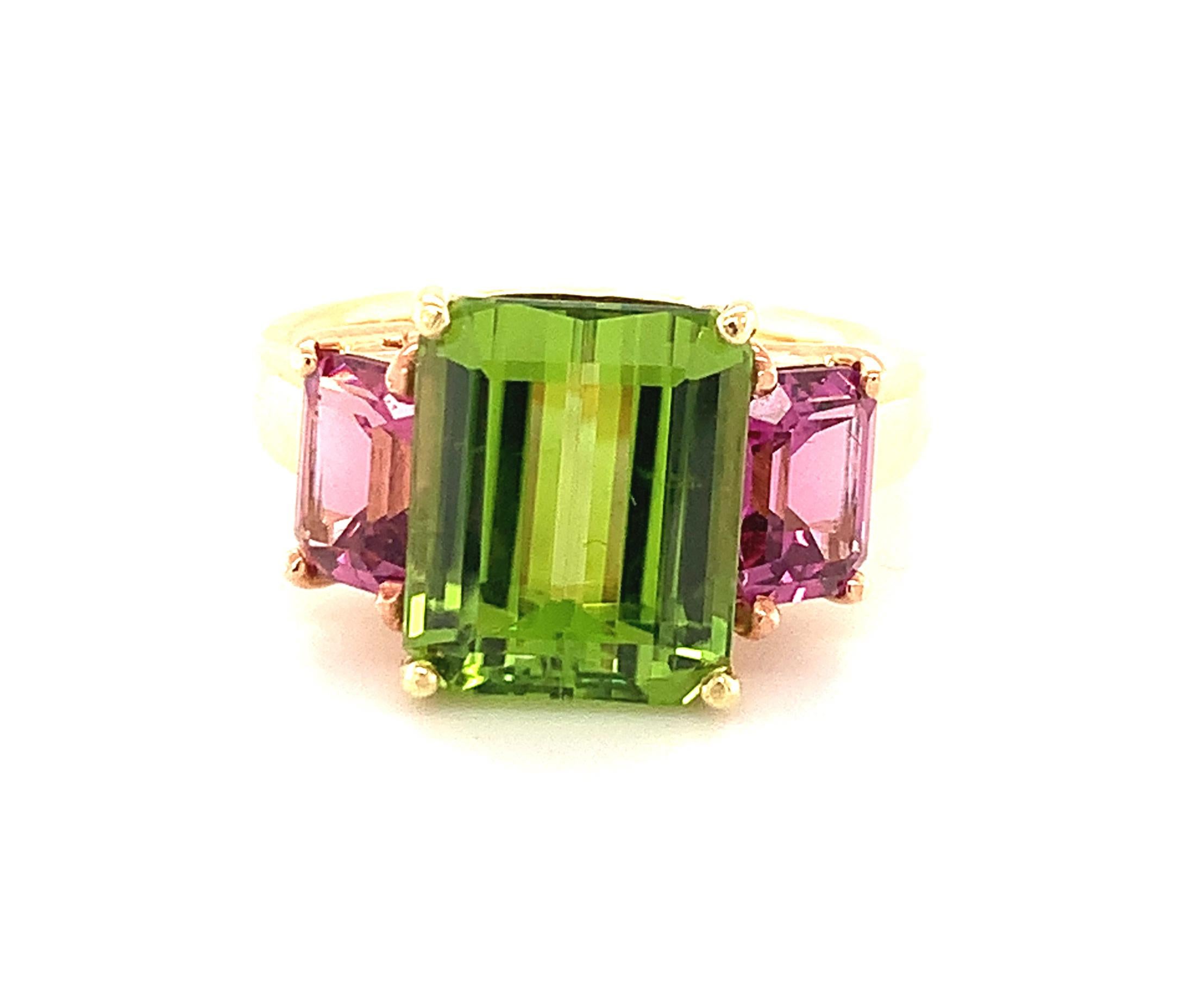 The cheerful pairing of bright, colorful gemstones makes this ring a joy to wear! A large, 5.49 carat grass-green peridot sits front and center, flanked by a pair of raspberry color rhodolite garnets in a sparkling pink and green combination that is