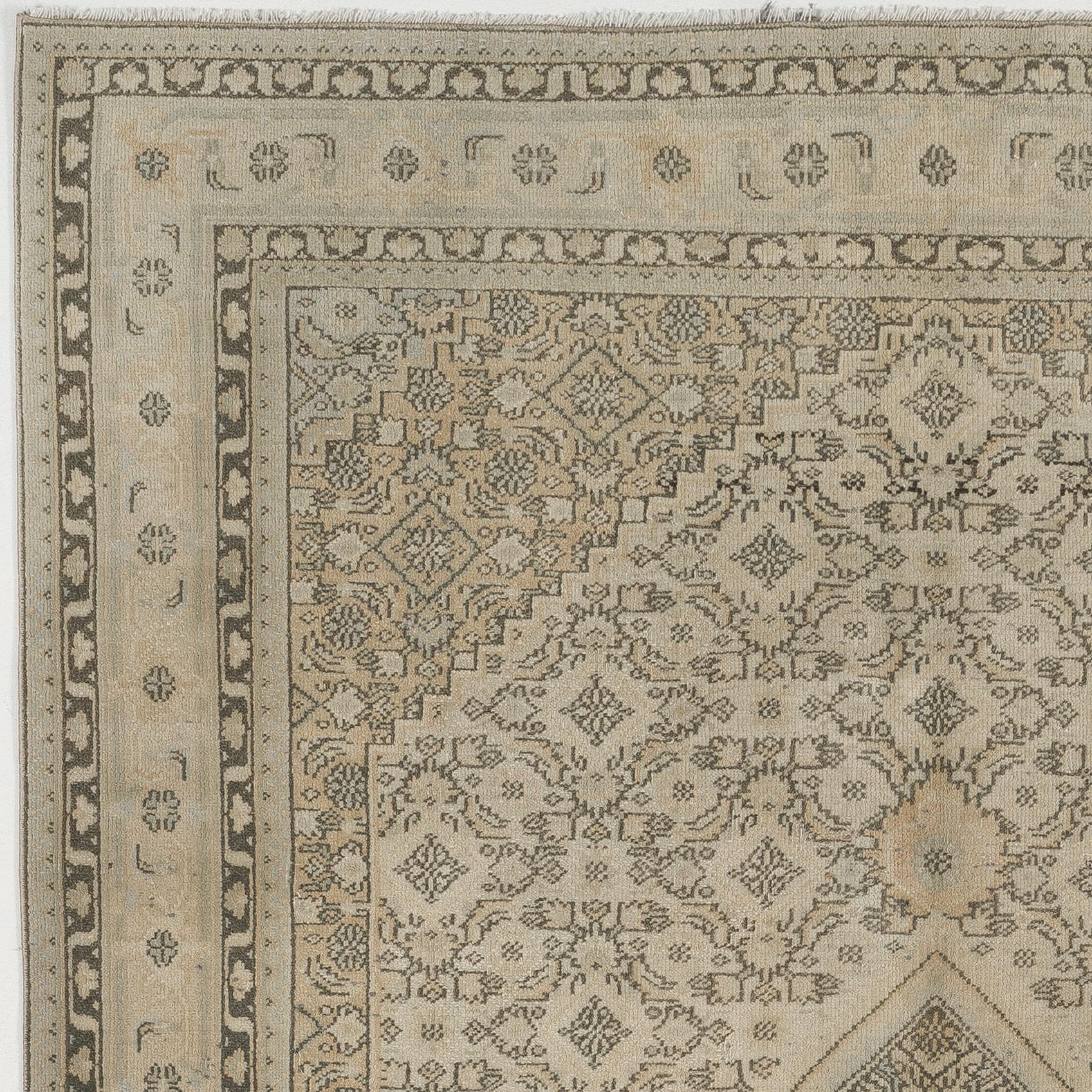 A finely hand-knotted vintage Turkish carpet from 1960s with a beautiful, nuanced color palette of soft, neutral tones including stone beige, light brown, very light sage green as well as dark green tinged with black.  The rug features a lozenge