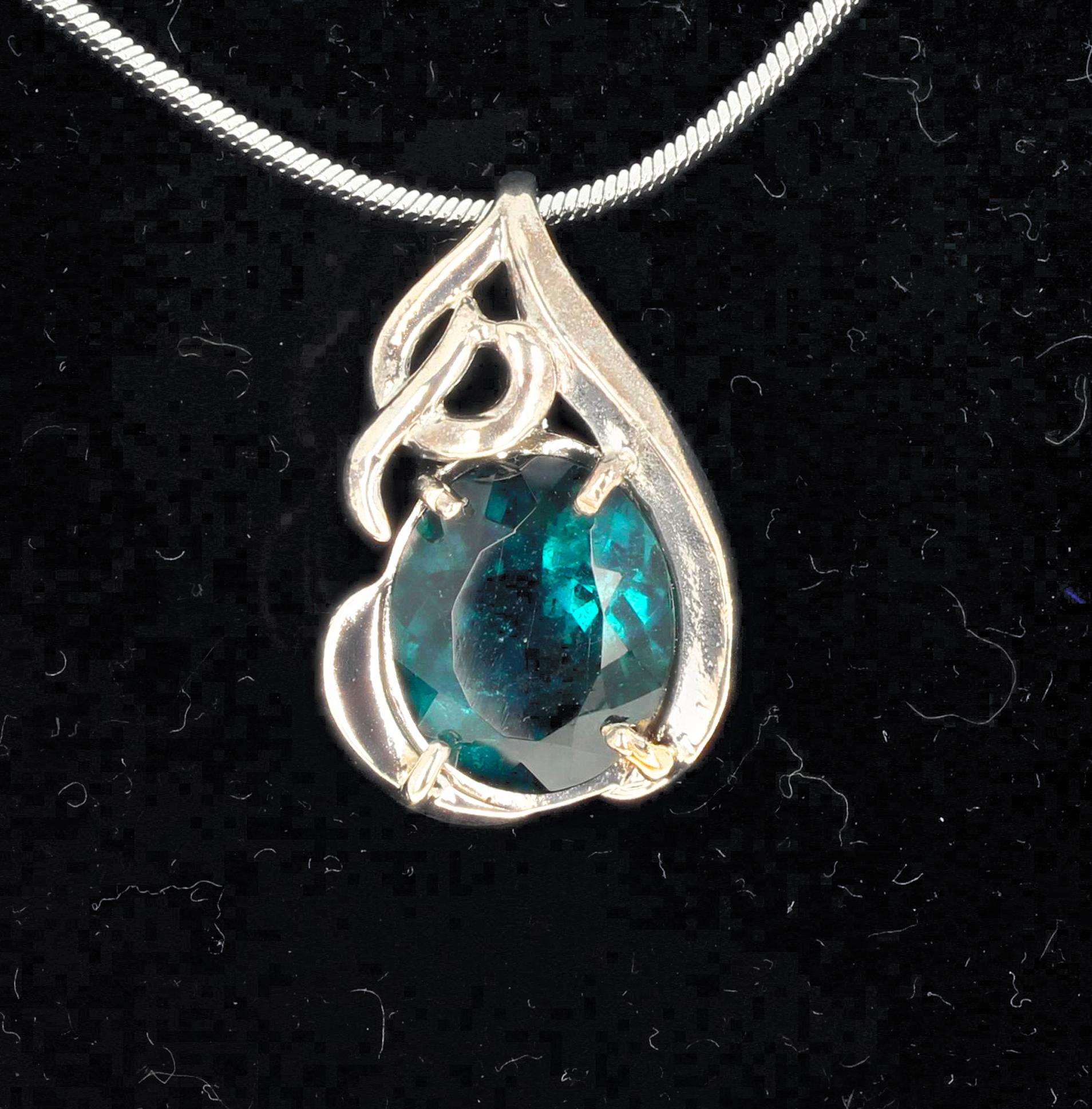 This 5.5 carat glittering beautiful rare natural blue green color Tourmaline is set in a sterling silver pendant.  The gorgeous Brazilian Tourmaline is 11 mm x 13 m and the pendant is one inch long.  Chain not included.  