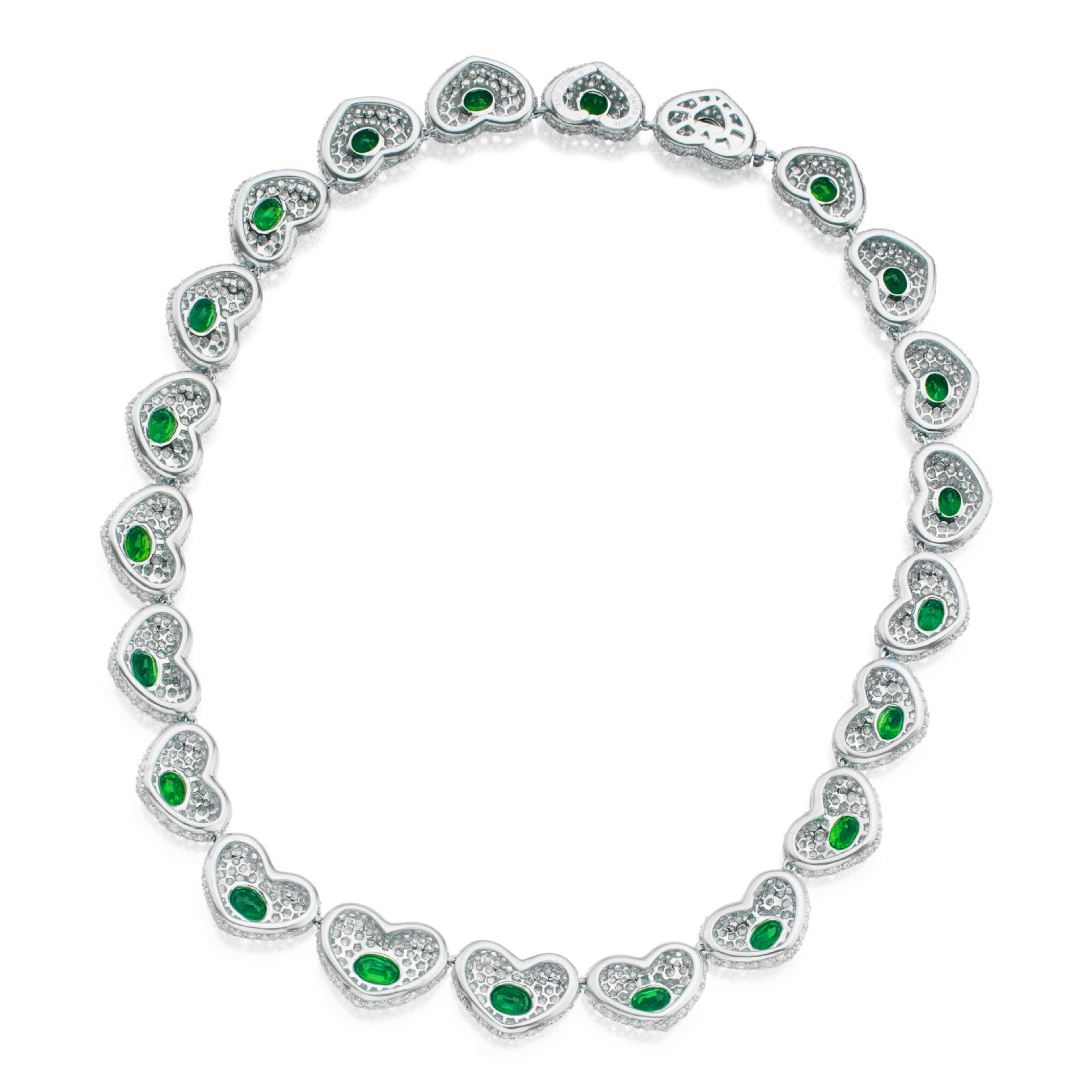  Atemberaubende Halskette in Form einer Reihe von abgestuften Herzmotiven, in deren Mitte sich jeweils ein wunderschöner ovaler Smaragd befindet. Dieses exquisite Stück ist mit funkelnden runden Diamanten in Pavé-Fassung besetzt, die ein