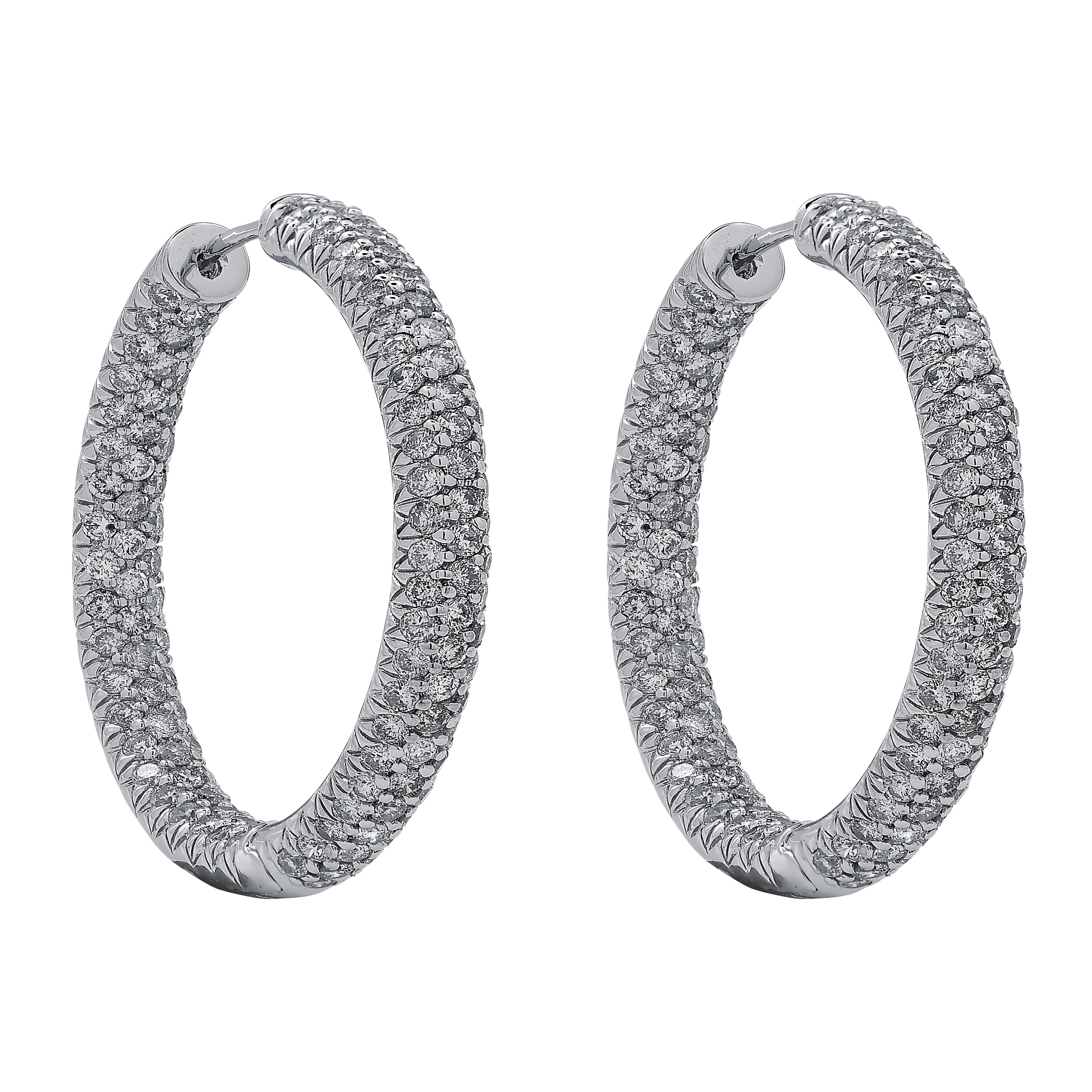 Dazzling pave diamond In/Out hoop earrings crafted in 18 karat white gold. These stunning earrings are pave set with diamonds weighing approximately 5.5 carats total, G-H color, SI clarity. The diamonds are set on the outside and the inside of the