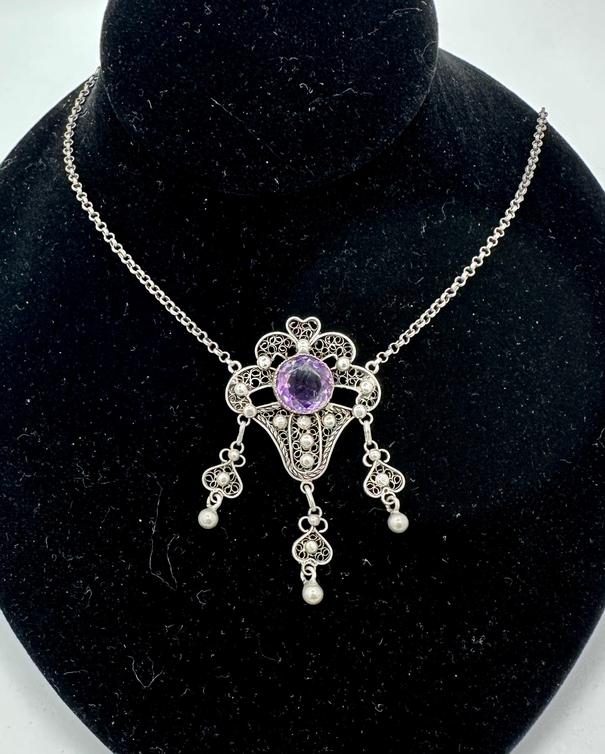 This is a magnificent Arts & Crafts Jugendstil Pendant Necklace in Silver with a gorgeous Rose De France Amethyst in the center and dating to circa 1900. 
The central Rose de France Amethyst is a stunning round faceted gem of 12mm in diameter and