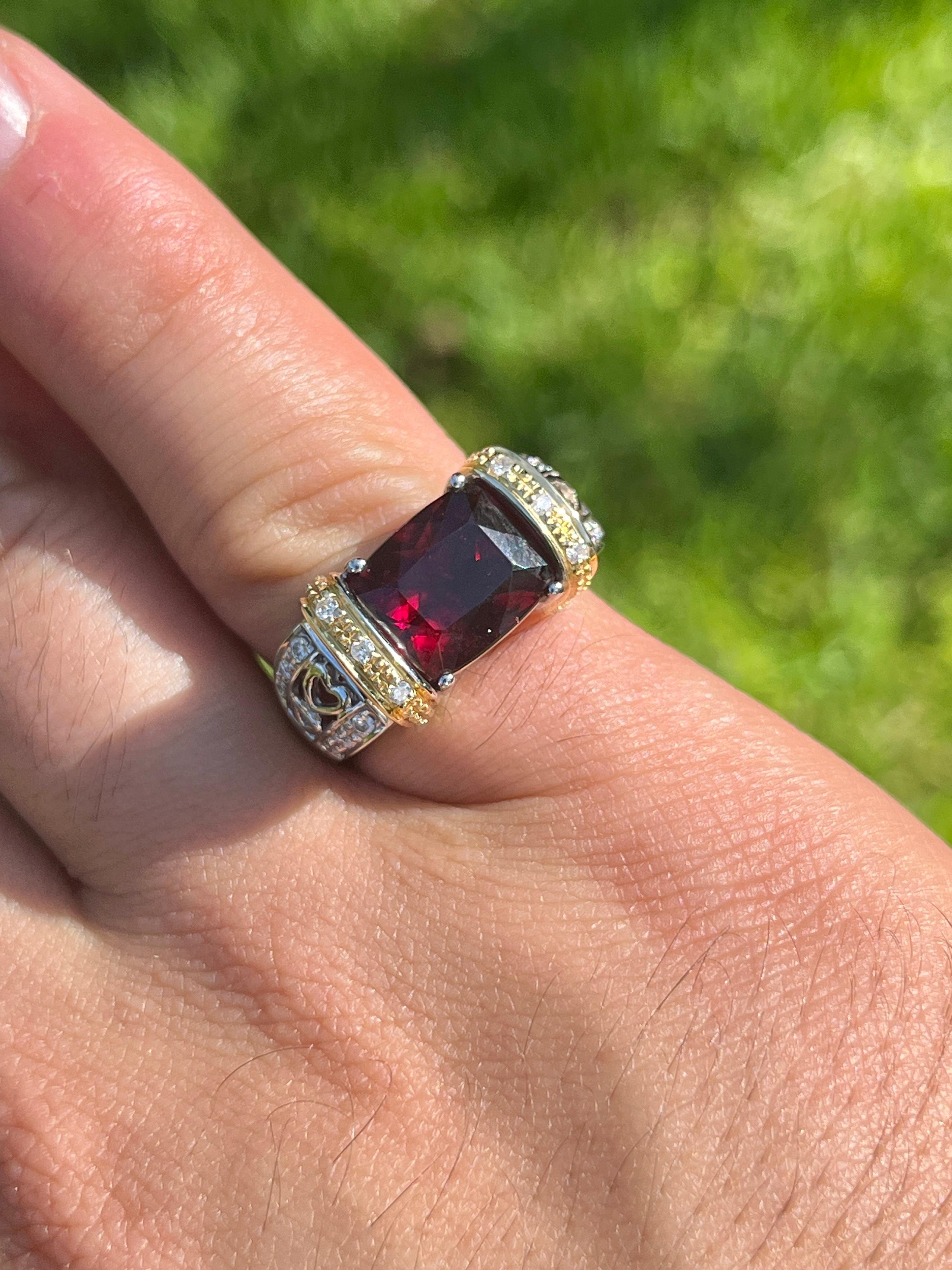 Vintage radiant cut 5.50 carat red Rubellite Tourmaline with 0.30 CTTW in diamond side stones with heart motif filigree ring shank. Crafted in 18K White and Yellow Gold east/west style setting, this semi-precious gemstone ring weighs 12.2 grams and