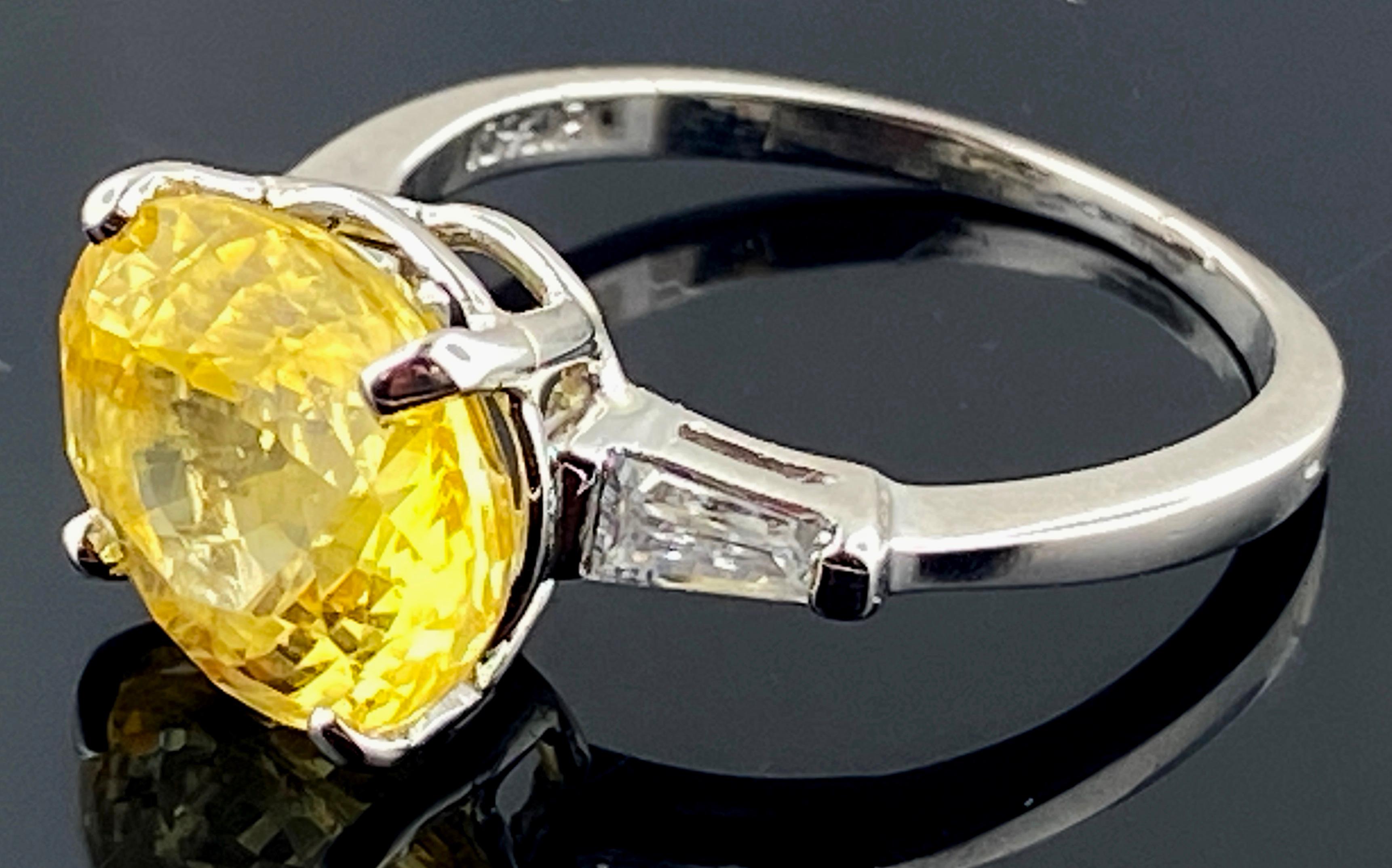 Ring features a East-West set Oval 5.51 carat Yellow Sapphire with two small tapered baguette diamonds on the sides.  Set in Platinum, with a weight of 5 grams.  Ring size is 7.