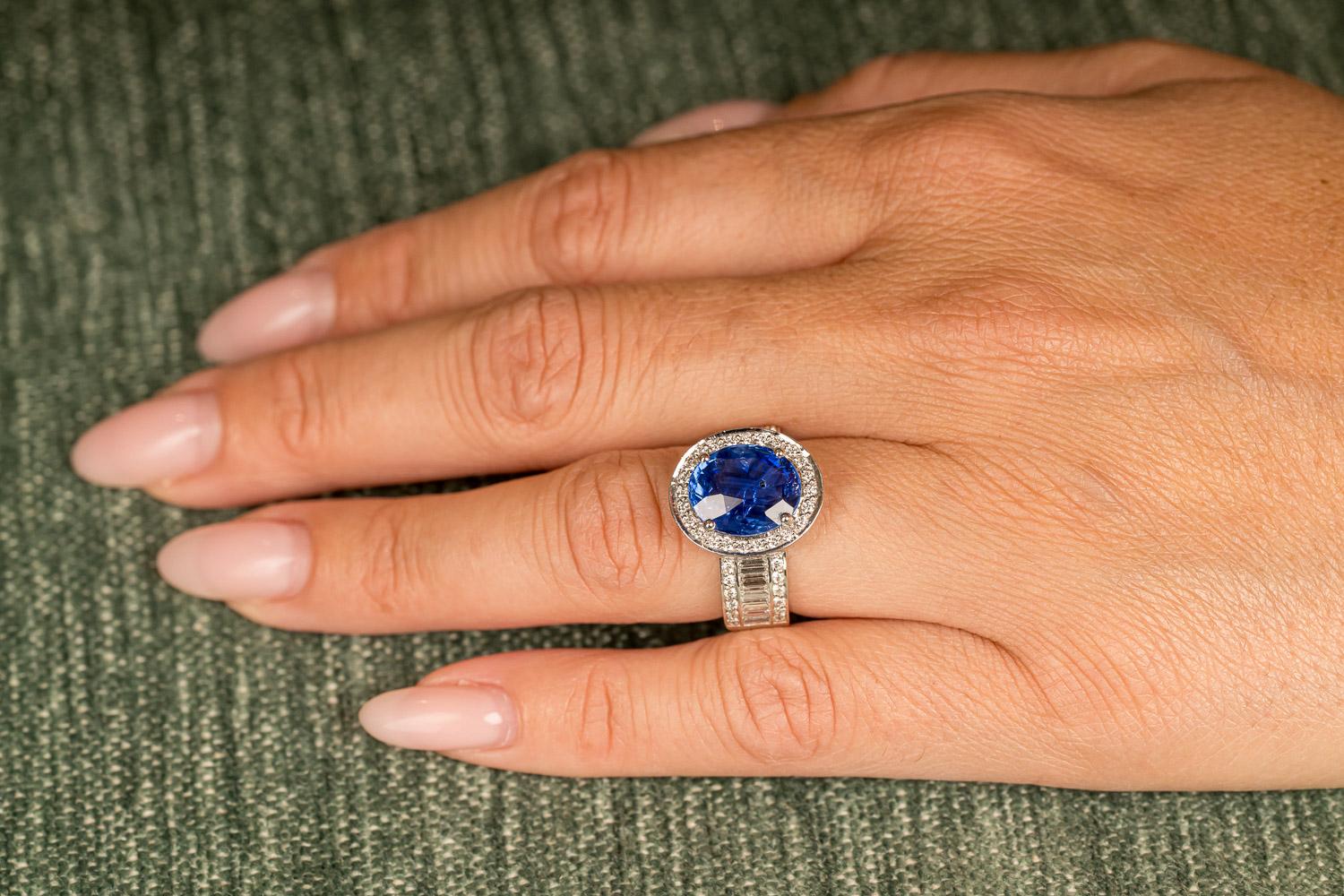 Einzigartiger Ring aus 18-karätigem Weißgold (11,7 g), besetzt mit einem natürlichen, augenreinen blauen Ceylon-Saphir im Ovalschliff (5,53 Karat), 12 Diamanten im Baguetteschliff (0,74 Karat) und 48 Diamanten im Brillantschliff (0,48 Karat) in