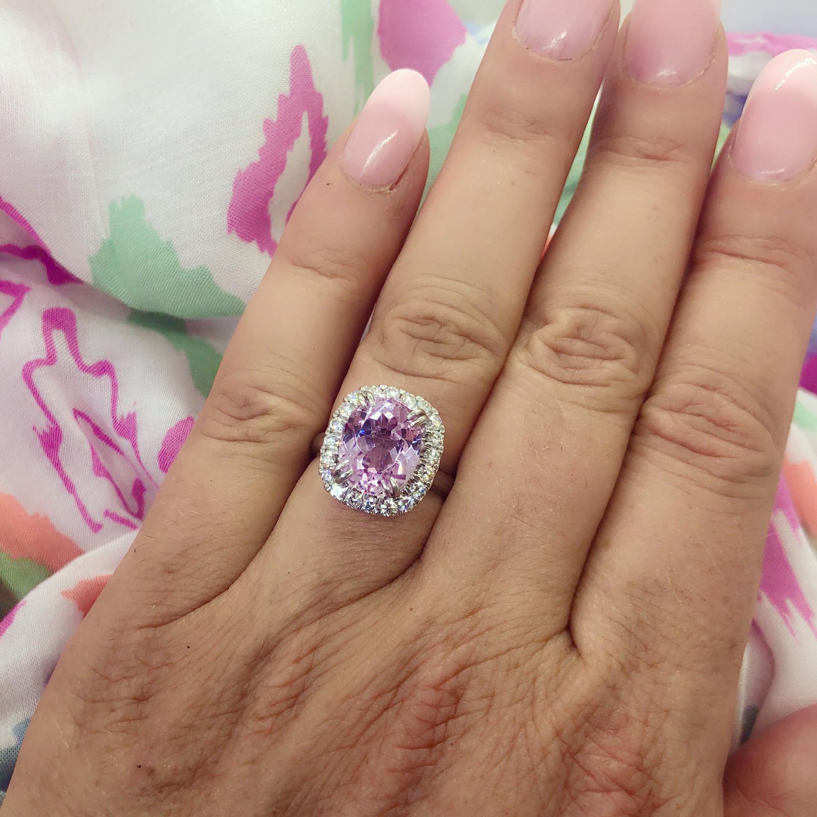 Think pink!! This Princess Diana design platinum ring features a pleasing oval-cut kunzite weighing 5.53 carats, set within a halo of 20 round brilliant-cut diamonds totaling 0.60 carat. The ring weighs 9.5 grams and is currently size 5.75, with