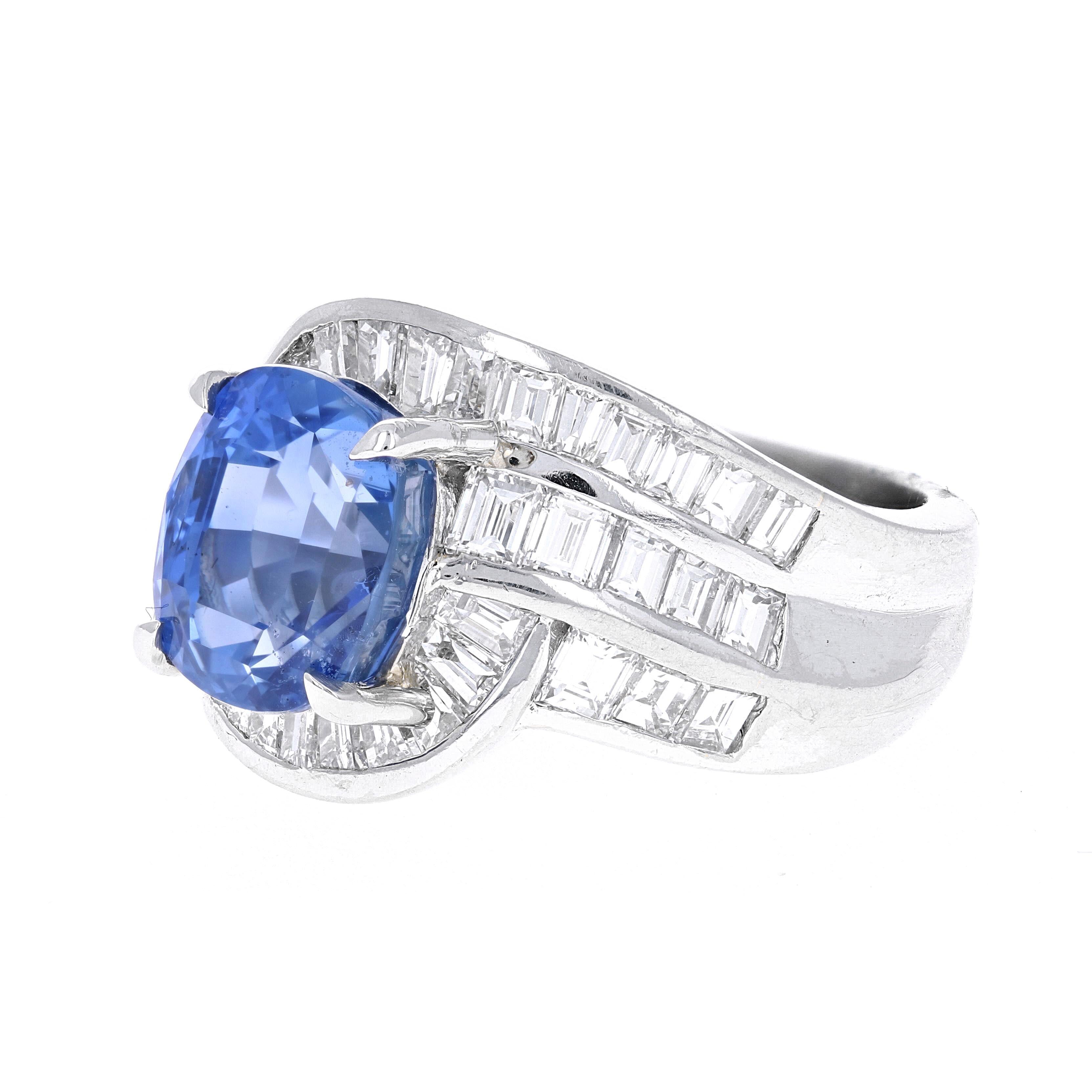 Cette bague cocktail en saphir bleu et diamant de 5,54 carats est magnifiquement réalisée dans une monture en platine unique. La monture est composée de 30 baguettes en diamant, de couleur G-H et de pureté VS-SI, pesant environ 2,39 carats. Le