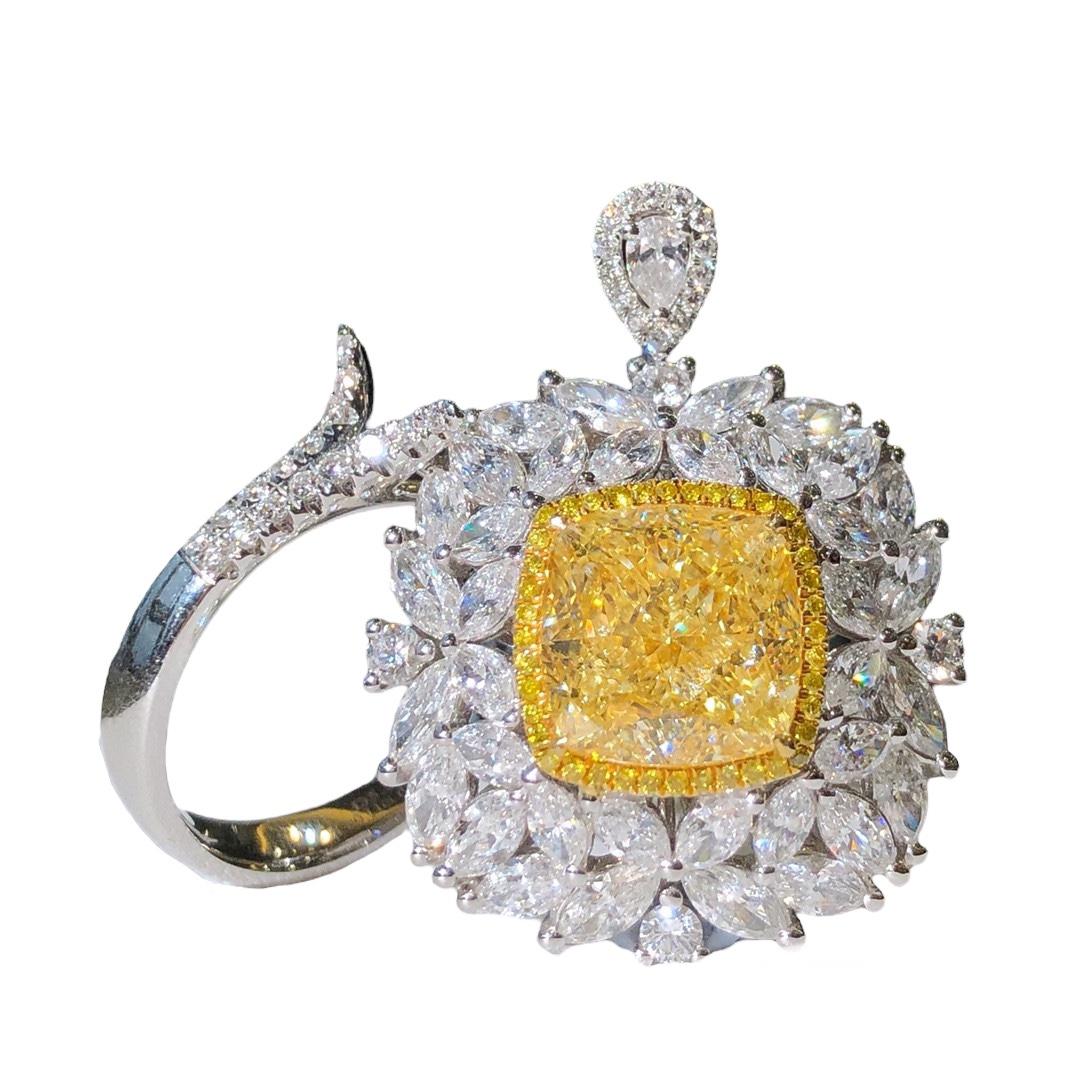 We invite you to discover this majestic ring set with a cushion cut Fancy Light Yellow diamond of 5.55 carat GIA certified enhanced with a halo of yellow diamonds and colorless  marquise cut side diamonds weighing 3,46 carats in total. The surprise