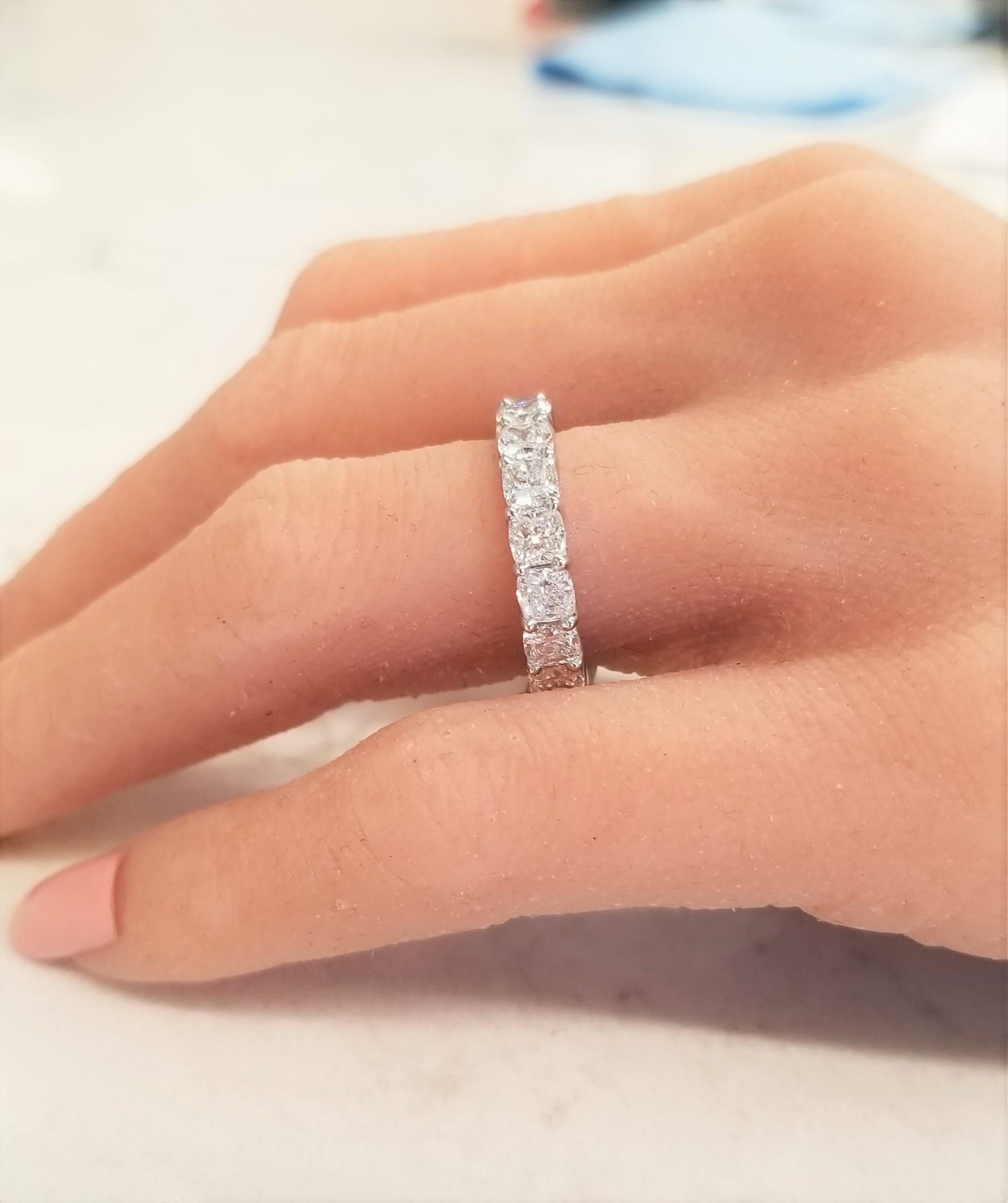 This is an impressive eternity wedding band that boasts 18 square cushion cut diamonds that have been expertly prong set all the way around totaling 5.55 carats. The diamonds are F in color and VS in clarity. They are perfectly matched, measuring