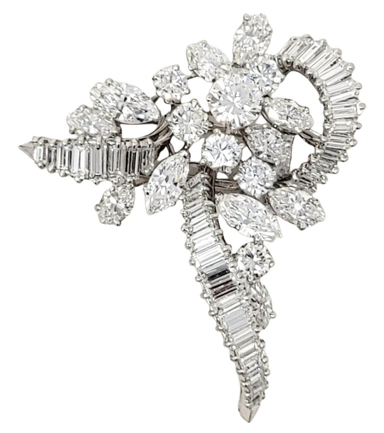 Featured here is an absolute showstopper of a brooch! Exquisite, icy white diamonds dazzle brilliantly throughout every inch of this piece. Made of polished platinum, this clustered diamond brooch combines 54 baguette, round and marquis shaped
