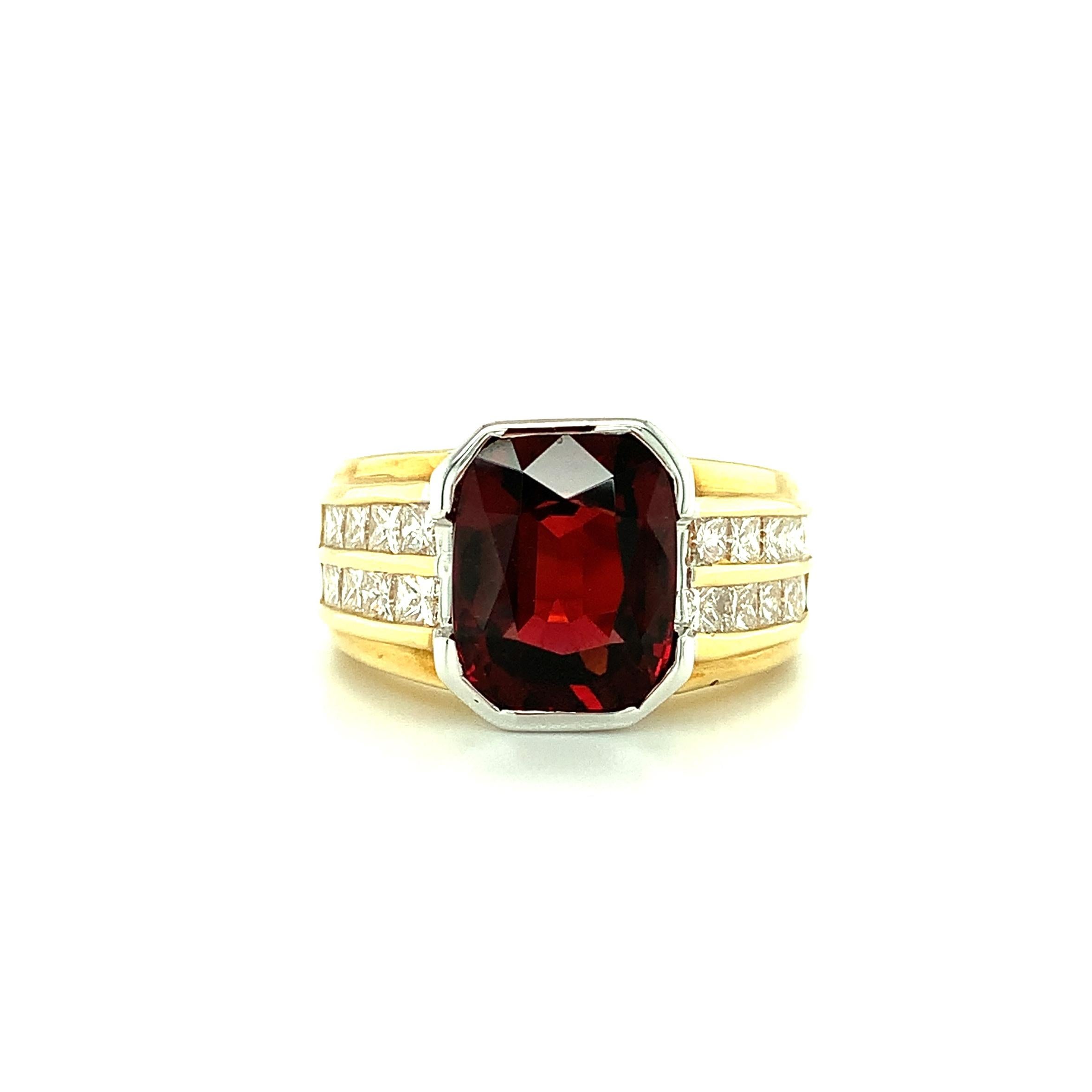 This bold band ring features a gorgeous 5.56 carat emerald-cut, bright red garnet and over a carat of diamonds! The center gem has such rich color and is beautifully faceted and proportioned. It is mounted in a striking 18k white gold half-bezel