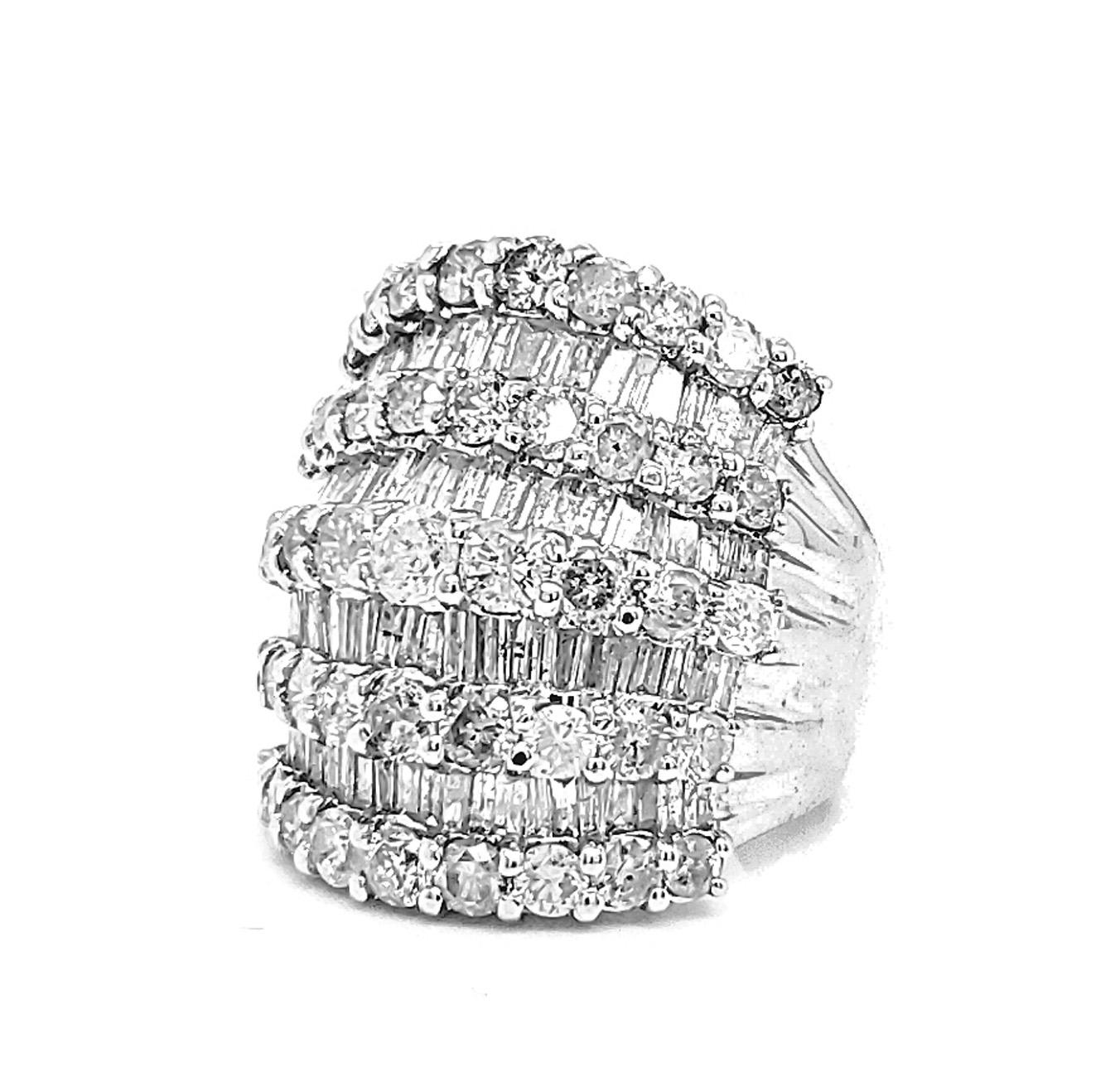 The 5.56 Carat White Diamond Statement Ring made by Shimon's Creations can dazzle any crowd. This ring has 9 rows of diamonds with a lovely pattern of baguettes and round cut stones. The 18k white gold ring features 3.69 carats of round cut white