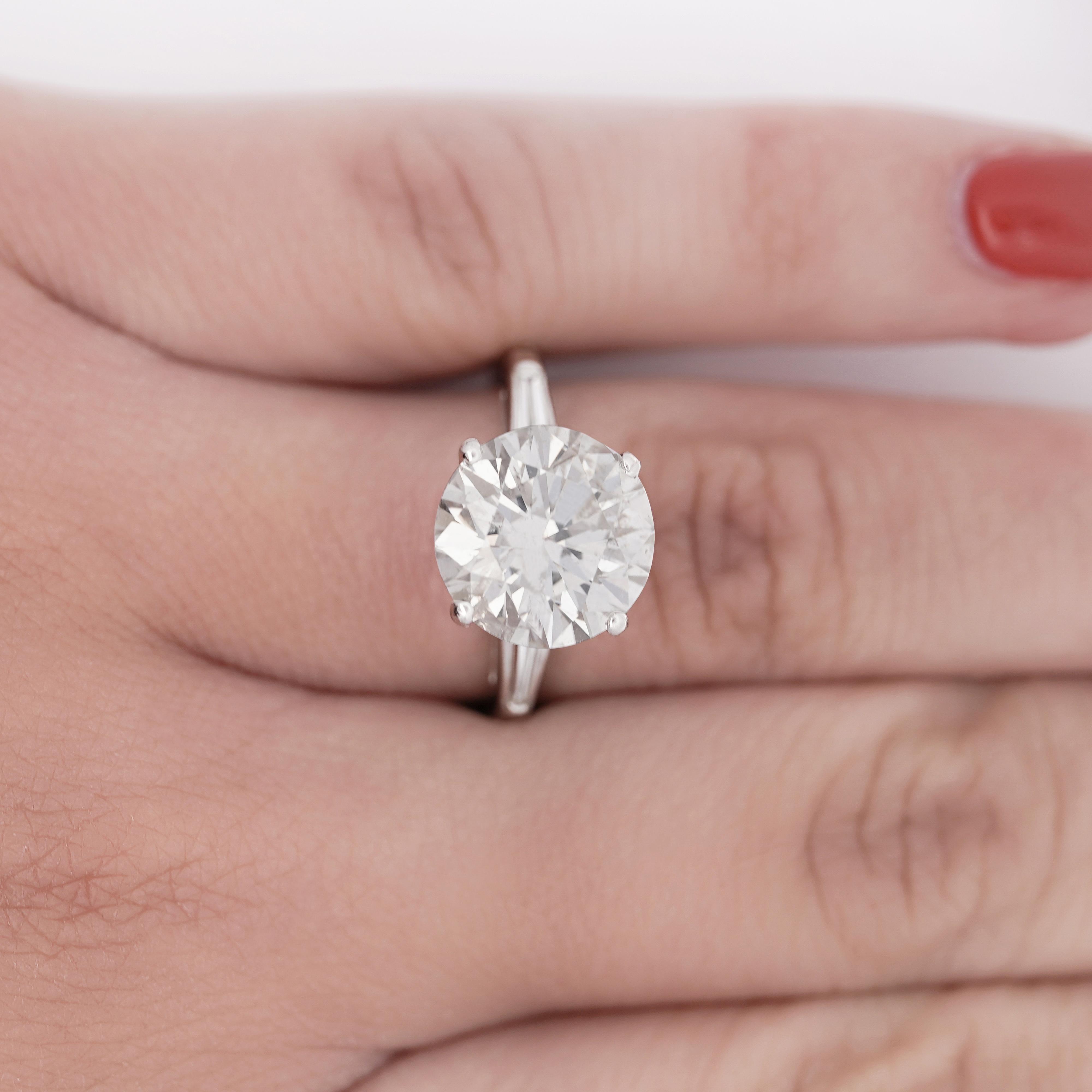 Anello di fidanzamento a tre pietre con diamante naturale a taglio rotondo certificato EGL da 5,58 carati con colore G e purezza I1. Misura 6,5 e incastonato in platino con 3 pietre laterali di diamanti taglio baguette. 

Dettagli: 
Tipo di