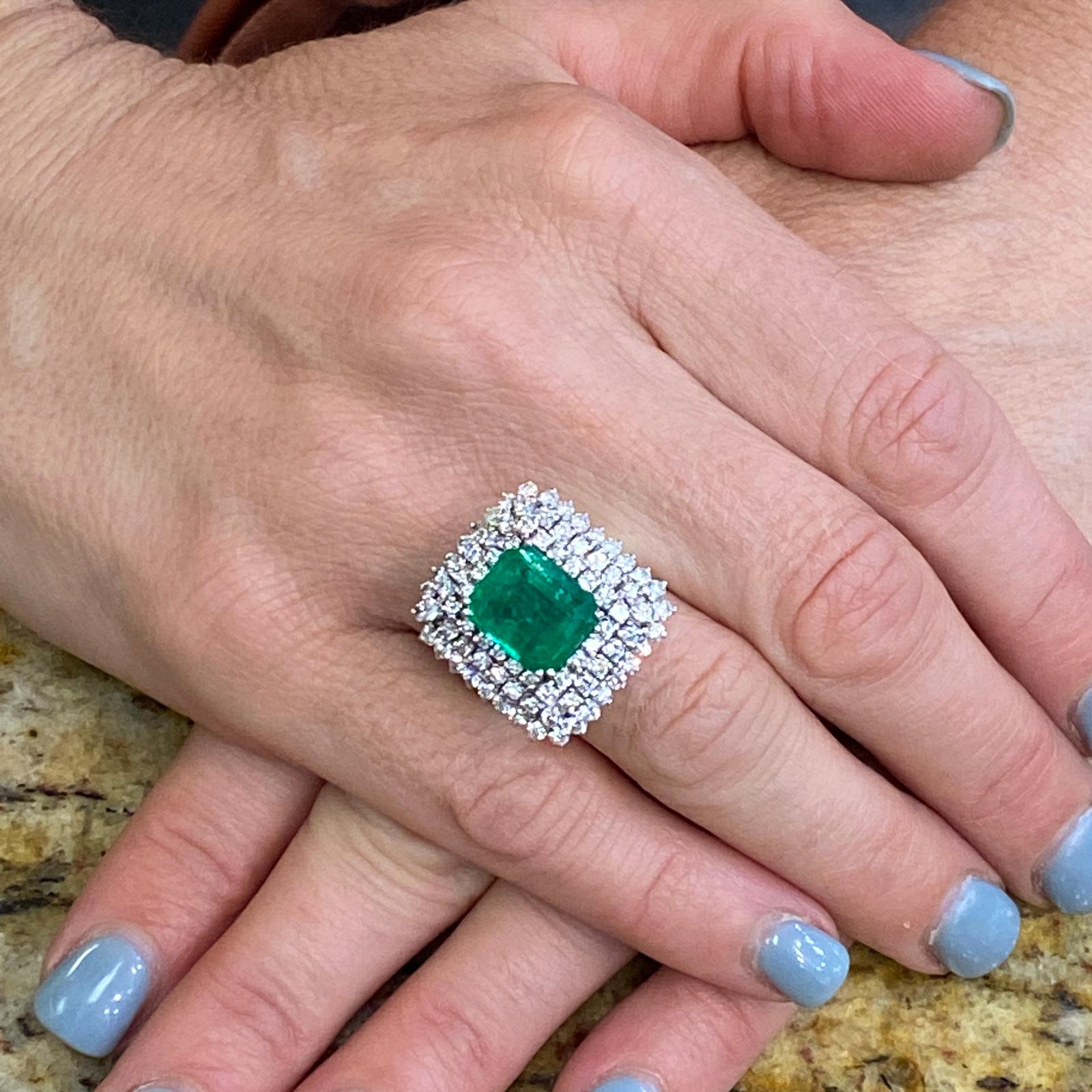 Beautiful emerald diamond cocktail ring handcrafted in platinum. The ring features a 5.59 carat bright green emerald of Afghanistan origin with minor treatment and certified by the AGL. The 89 round brilliant cut diamonds weigh 2.00 carat total