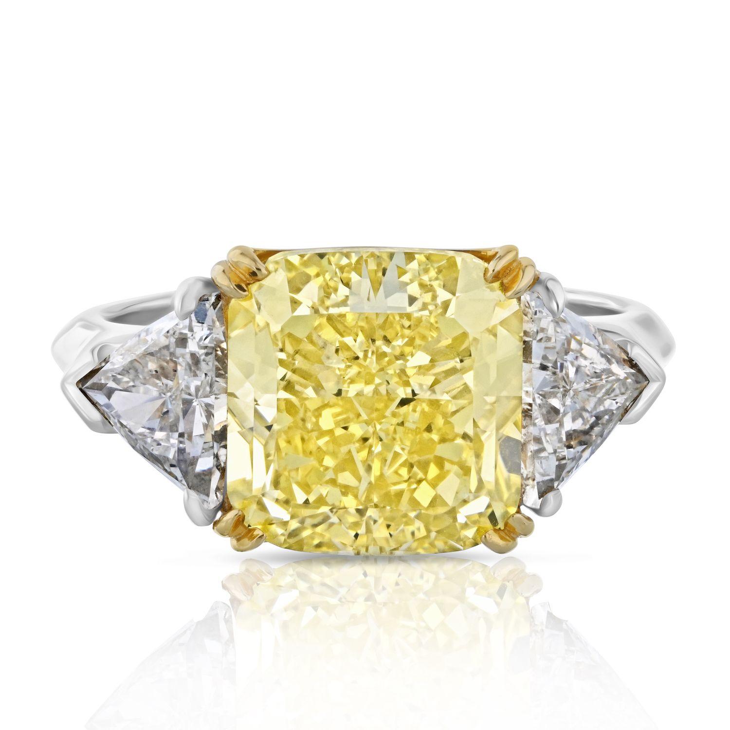This is a beautiful square radiant cut diamond engagement ring mounted in a handmade setting. The center diamond is a 5.59 Carat Fancy Vivid Yellow Diamond, extremely rare and special. When searching for a fancy yellow diamond one of the main