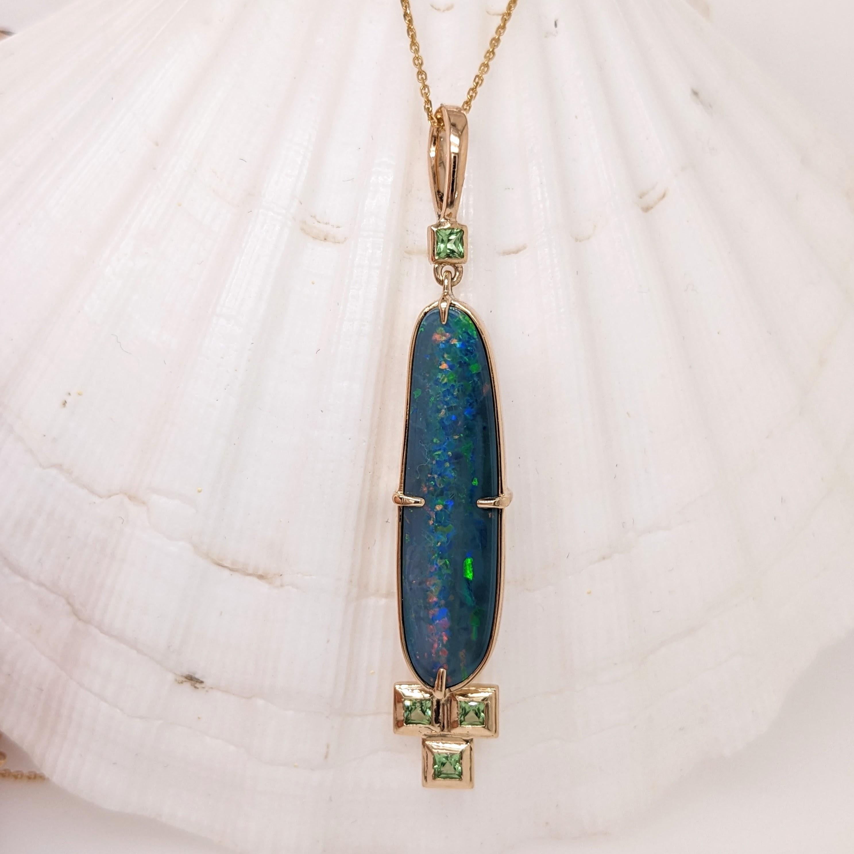 This beautiful pendant features a 5.55 carat oval boulder opal with 4 tsavorites, one at the top and 3 at the bottom of the opal, all set in solid 14K gold. This pendant is a statement piece showcasing the beauty of the opal. 

Specifications

Item