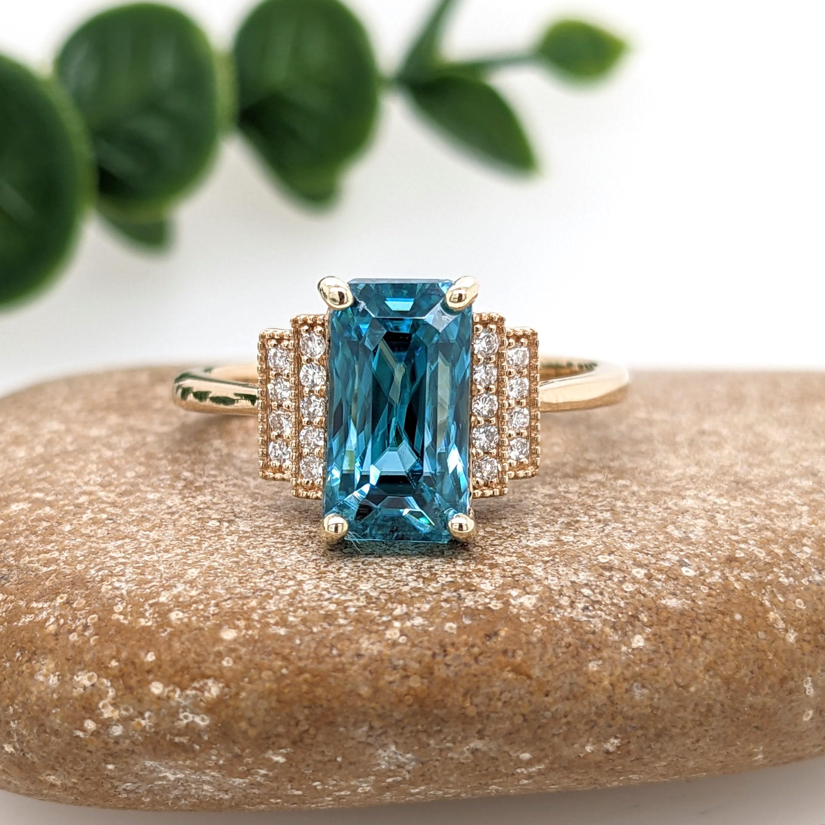 This statement ring features a gorgeous sparkling natural blue zircon in 14K solid yellow gold with natural earth mined baguette diamonds giving it an elegant modern feel. Zircons are celebrated for a refractive index that comes closest to diamonds,
