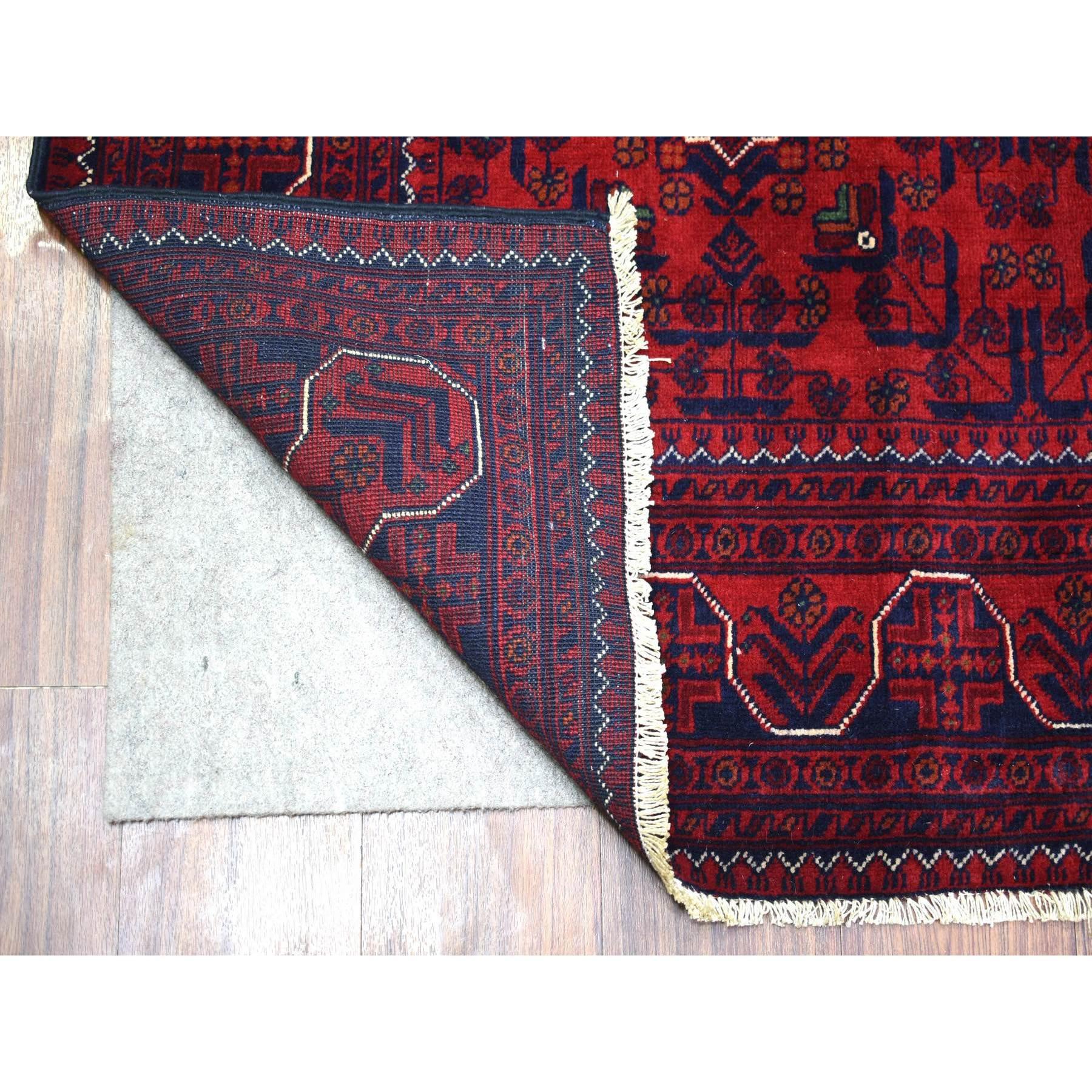 Il s'agit d'un véritable tapis d'Orient, unique en son genre, d'un rouge profond et saturé, Khamyab afghan à motifs géométriques, en laine douce et brillante, nouée à la main. Il a été noué pendant des mois et des mois selon des techniques de