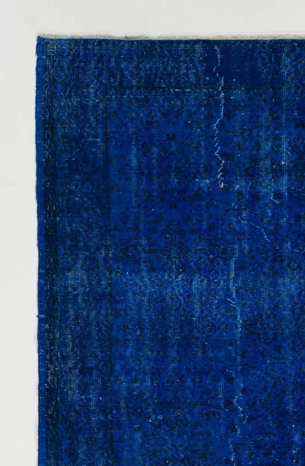 A vintage Turkish area rug re-dyed in blue color for contemporary interiors. Measures: 5.5 x 8.7 Ft.
Finely hand knotted, low wool pile on cotton foundation. Professionally washed.
Sturdy and can be used on a high traffic area, suitable for both