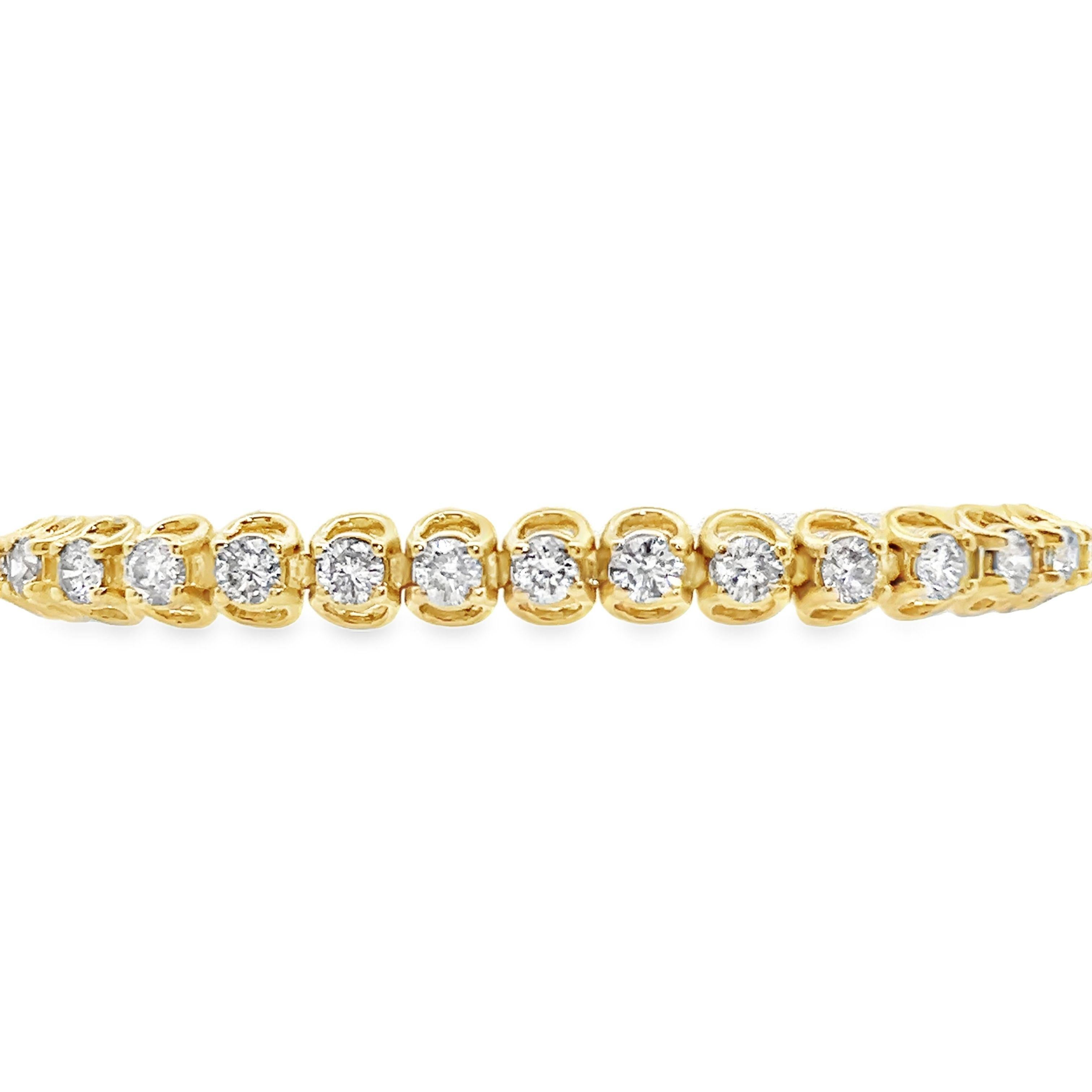 This is a diamond tennis bracelet made in 14k yellow gold with a fun and unique twist. The sides of this tennis bracelet feature horseshoe shaped supports that end up becoming the prongs securely holding the sparkly diamonds to the bracelet. This