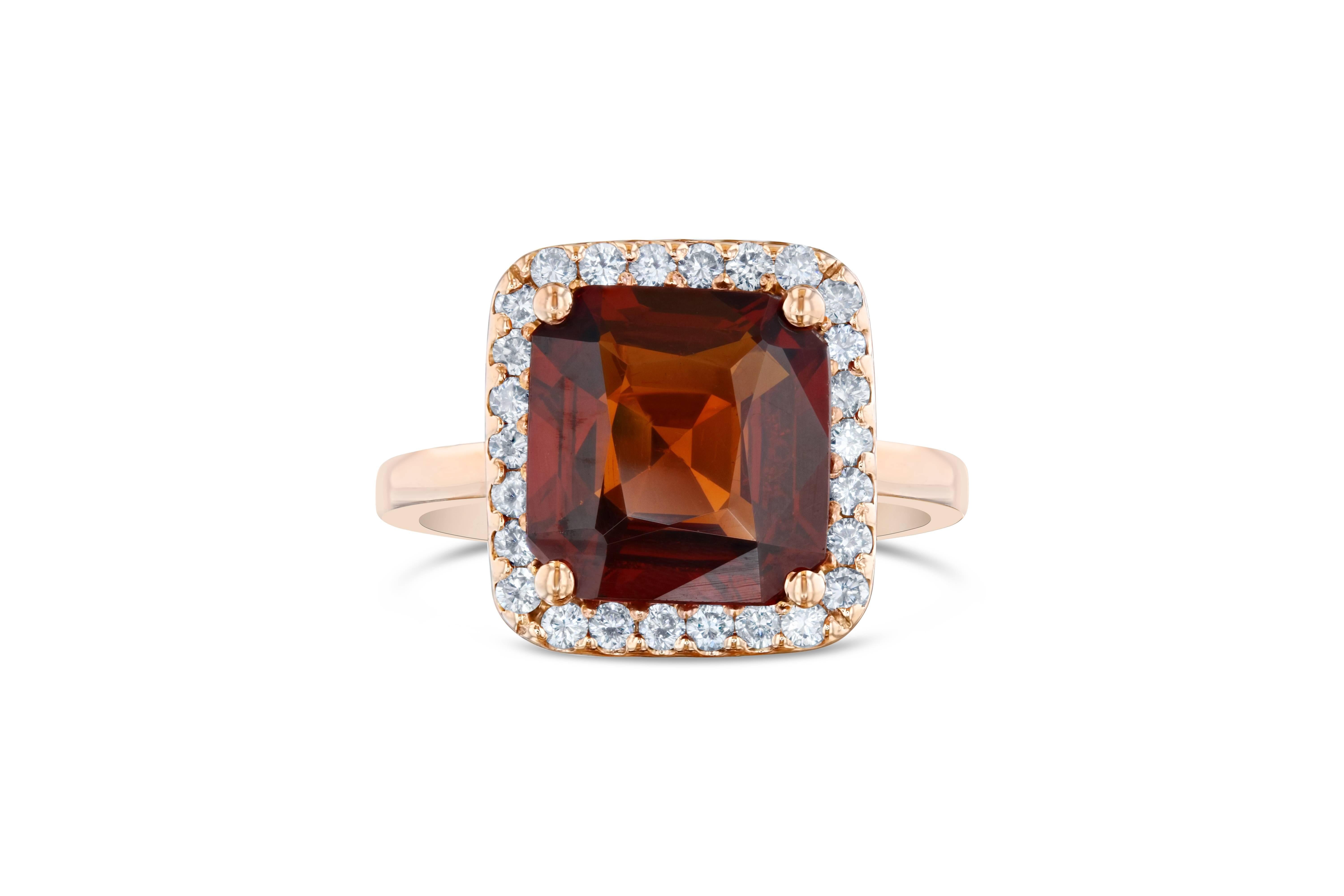 This beautiful ring has a 5.18 carat Square Cut Spessartine Garnet. Spessartines are natural gemstones within the Garnet Family. The ring is surrounded by a halo of 26 Round Cut Diamonds that weigh 0.42 carat. The total carat weight of the ring is