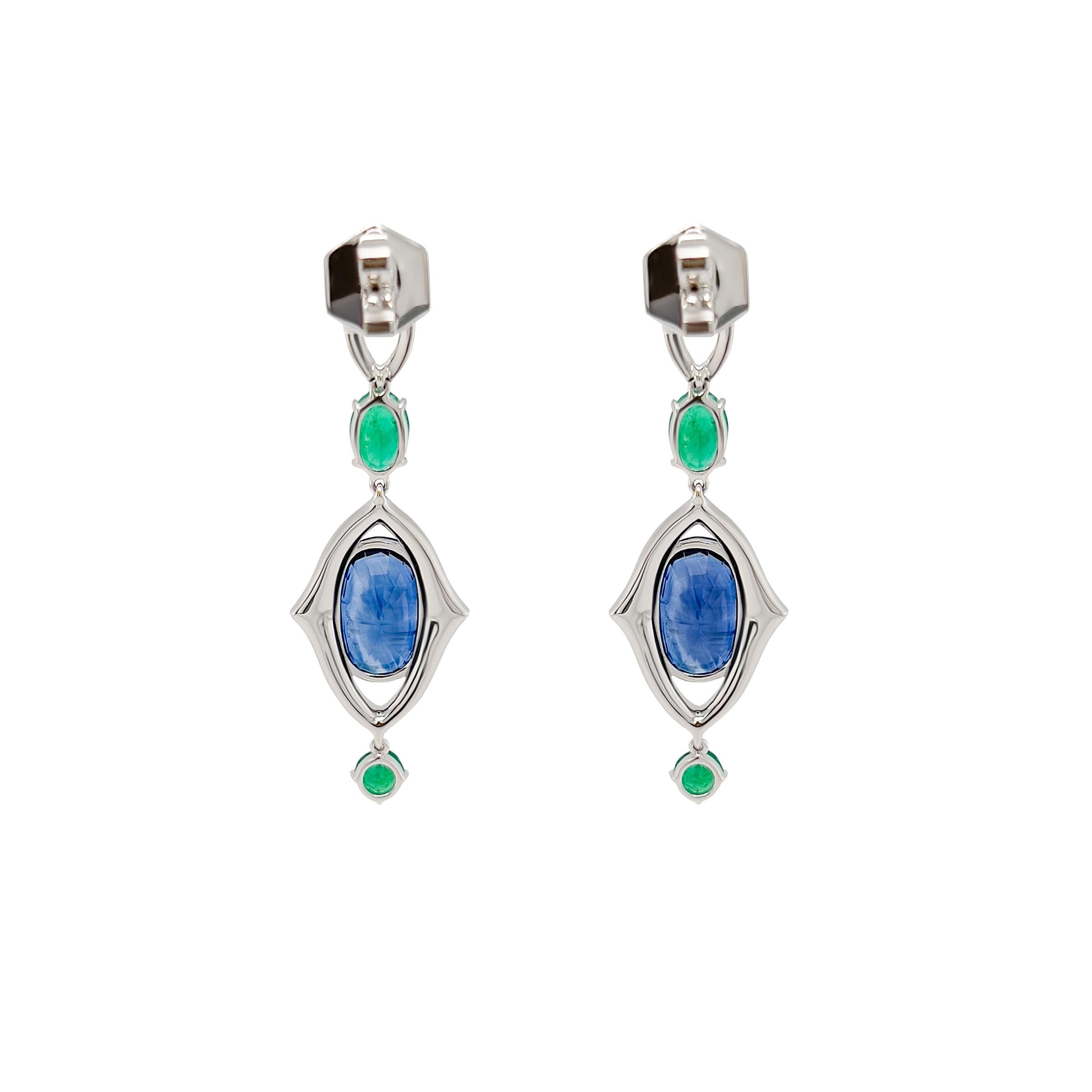 Deep blue oval cut sapphires from Sri Lanka accented with vivid Columbian emeralds. These dangle earrings are completed with pave'd diamonds in 18k white gold. Our diamonds are G VS to get the ultimate fire and sparkle. These earrings are