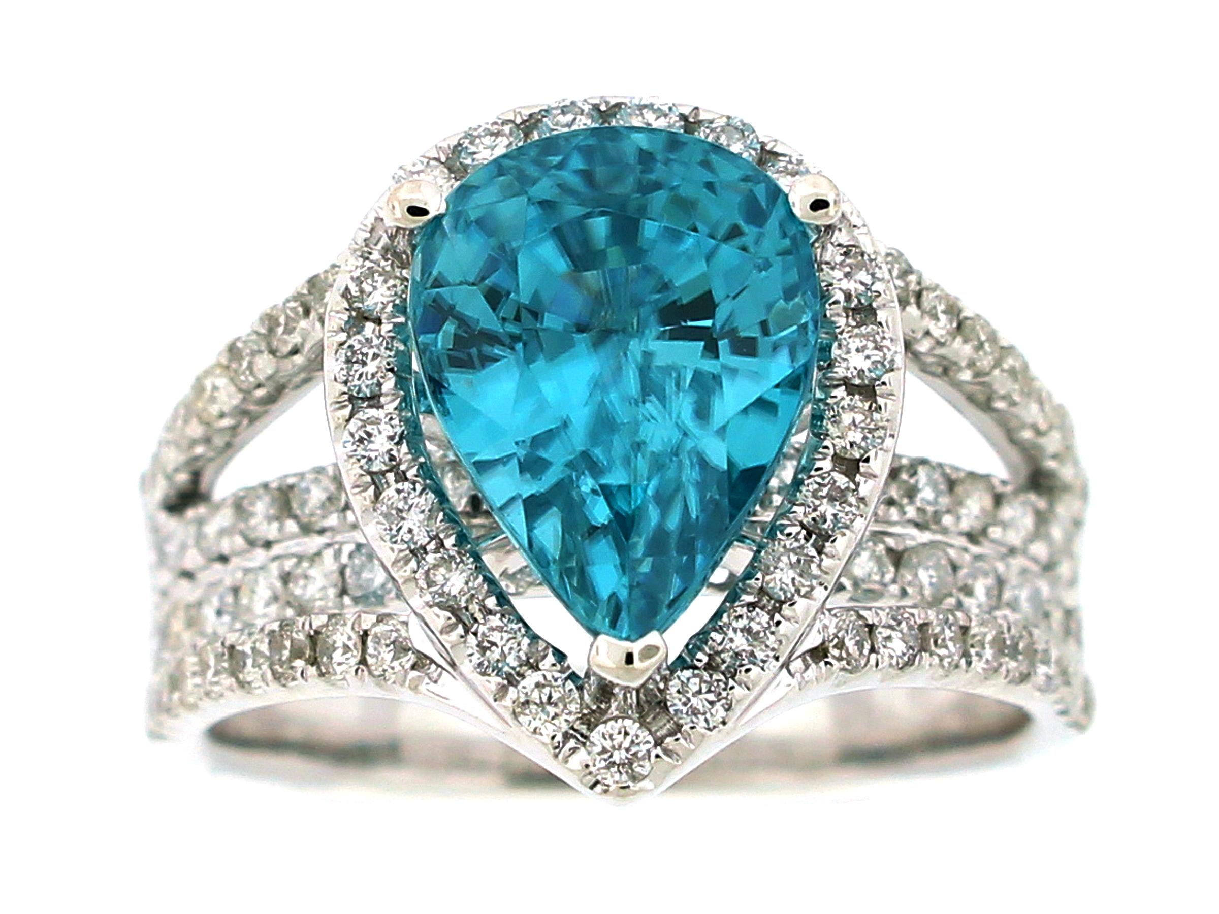 This stunning cocktail ring showcases a beautiful 5.61 Carat Pear Shape Blue Zircon with a Diamond Halo on a quadruple diamond shank. This ring is set in 18k white gold. Total diamond weight = 1.01 carats. Ring Size is 7.