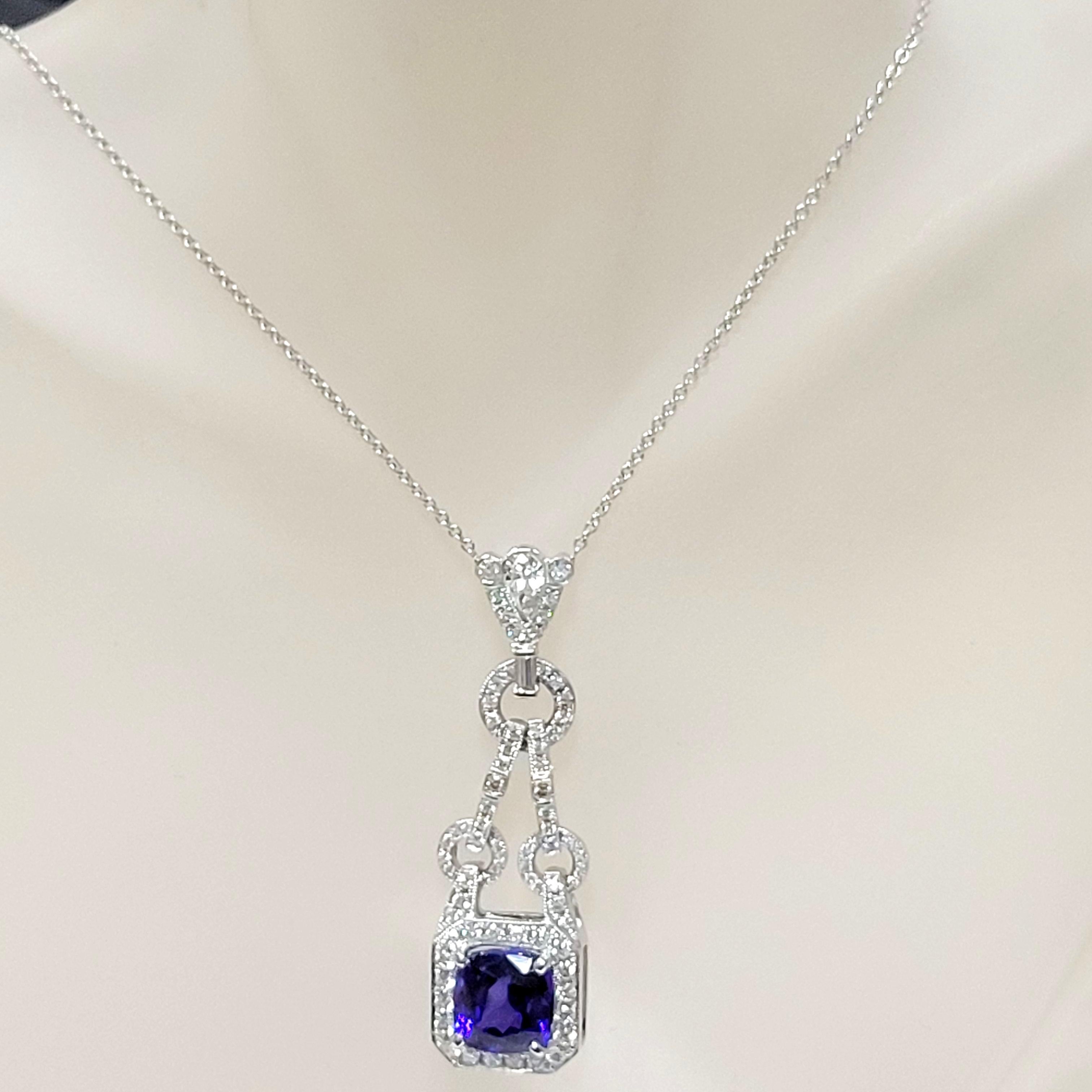 A beautiful color Cushion Shape Tanzanite sits in the center of a Beautiful  handcrafter antique design 14K Necklace pave set with 61 Perfectly matched Round Brilliant Diamonds, a 6.0x3.6 Pear shape diamond  and a 3.9x1.6 straight Baguette on its