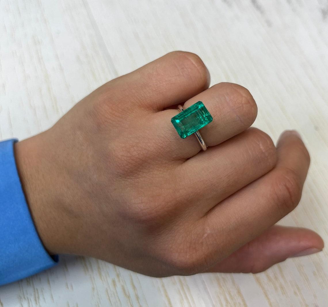Stone: Emerald
Weight: 5.63-carats
Shape: Emerald Cut
Clarity: Transparent
Luster: Excellent
Color: Bluish Green
Measurements: 12.71mm x 8.29mm x 6.39mm
Geographic Origin: Colombia
Treatment: Natural, Oiling

Comments: Due to their growth conditions