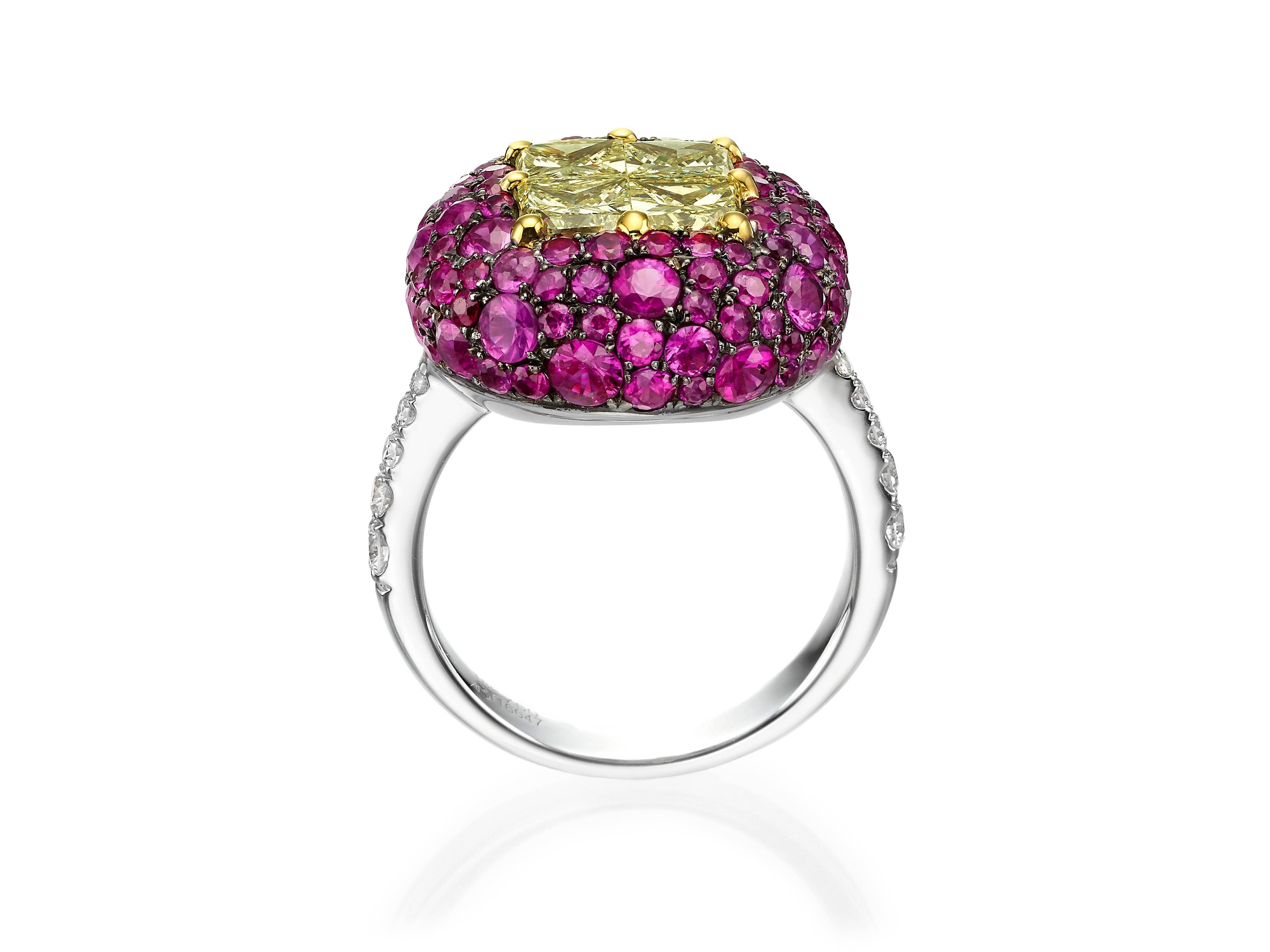 Handcrafted in 18K white gold, this stunning ring is centered with four yellow diamonds (totaling 1.84 carats) to create an illusion of one large single yellow diamond.  Surrounded by a cluster of 108 round red rubies (totaling 3.53 carats) and 0.29