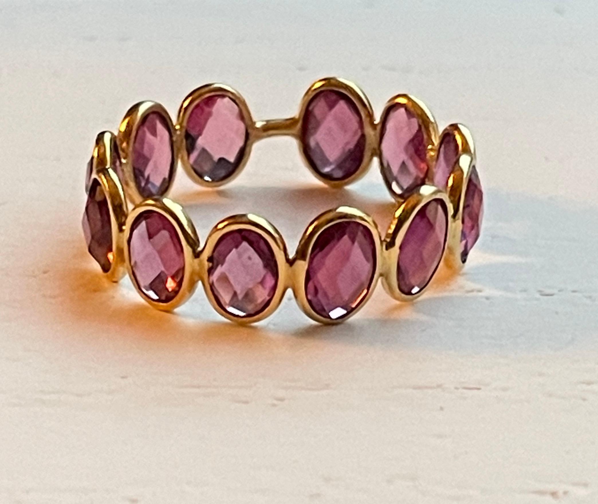 This gorgeous Rhodolite 18K Gold Ring is comprised of 12 checker cut ovals totaling 5.66 carats. The 18K gold bezel setting allows for the stones to showcase maximum shine and sparkle. The Ring is size 7. All stones are ethically sourced and hand