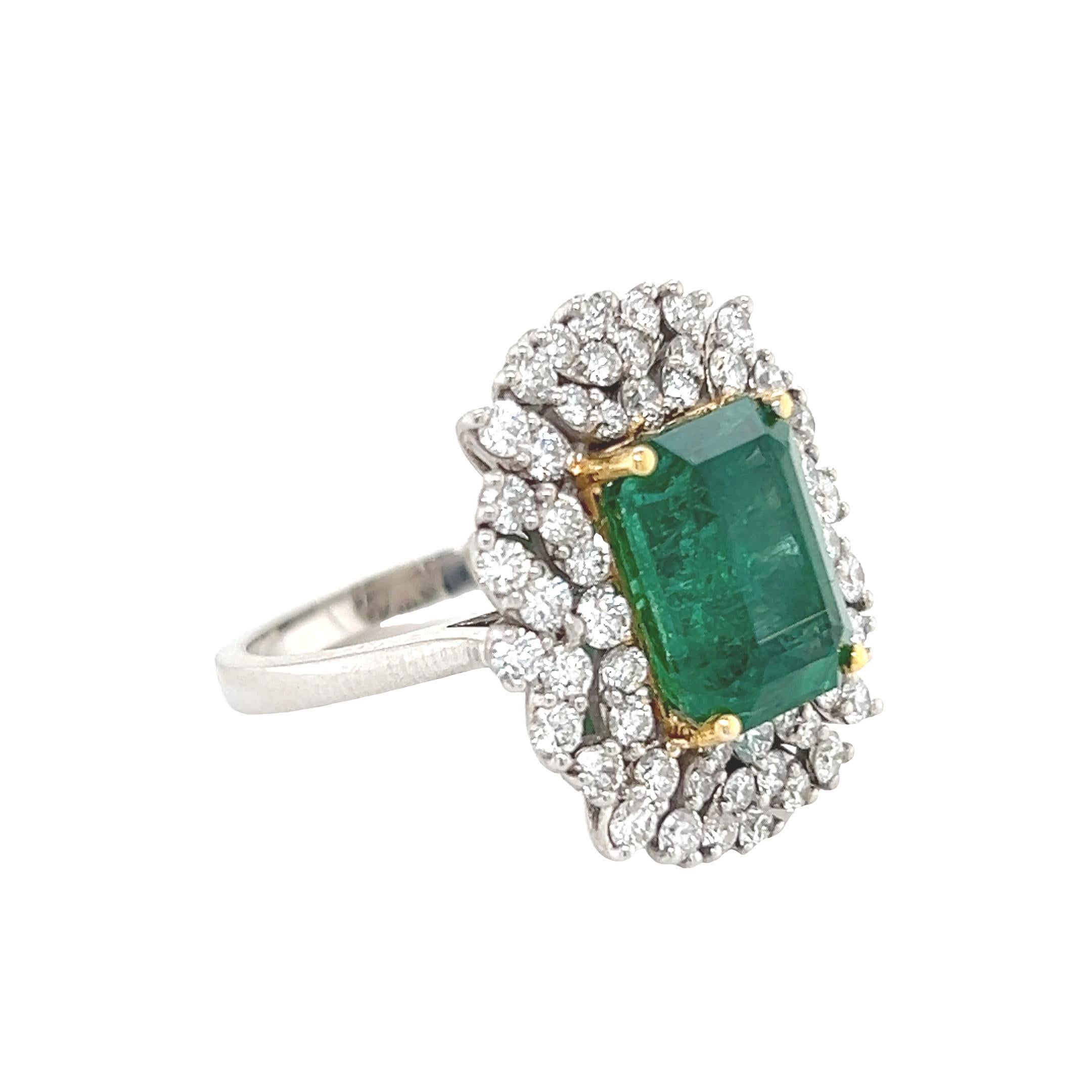 Charismatic emerald ring. High brilliance, rich grass green tone, emerald faceted, Zambian origin, natural 5.66 carats emerald encased in high profile with open basket with four yellow gold bead prongs, accented with round round brilliant cut