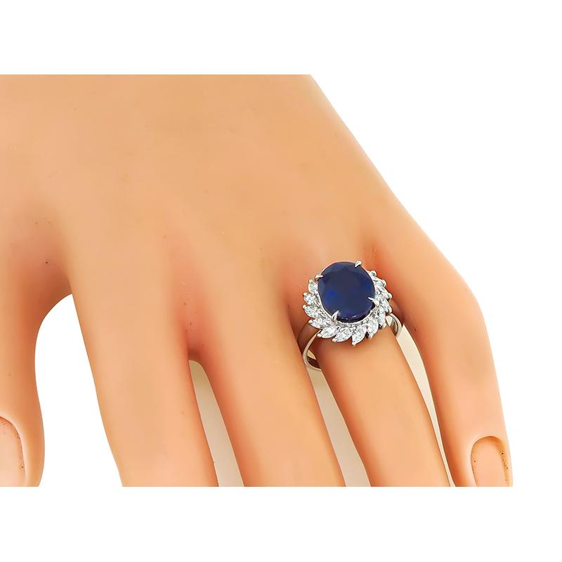 This is an elegant platinum engagement ring. The ring is center with a lovely oval cut sapphire that weighs approximately 5.66ct. The center stone is accentuated by sparkling marquise cut diamonds that weigh approximately 0.89ct. The color of these