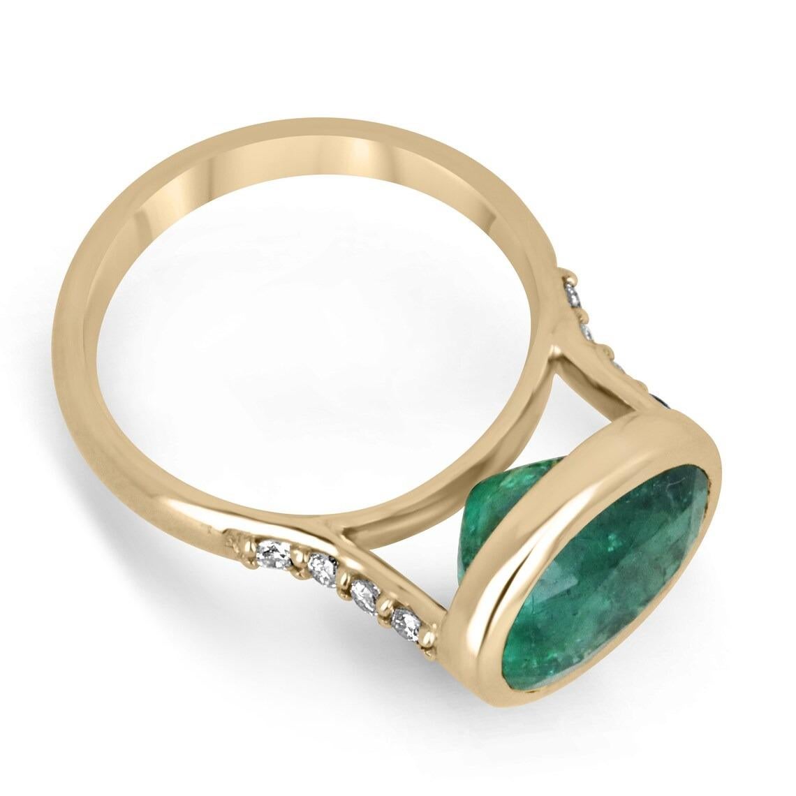 A gorgeous emerald and diamond ring. This beauty showcases a large oval cut emerald weighing over five carats, with remarkable characteristics such as its dark alpine green color, very good luster, and clarity. The center stone is skillfully bezel