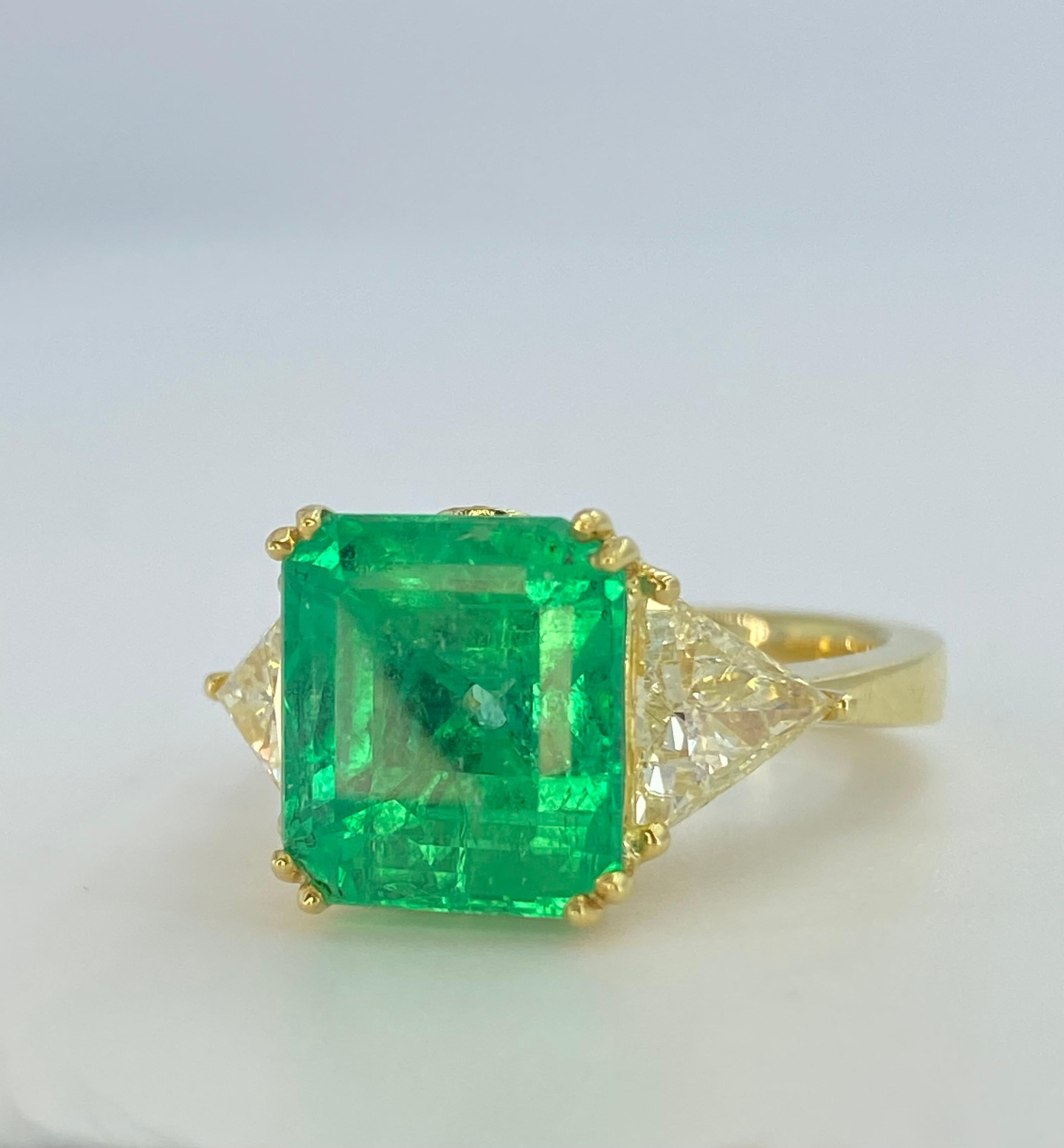 5.67 natural Colombian Emerald mounted in a vintage art deco ring setting. This remarkable Emerald is adorned with 1.15 carats in natural diamond side stones. Beautifully made in an art deco Euro ring shank. 

This Emerald was sourced years ago from
