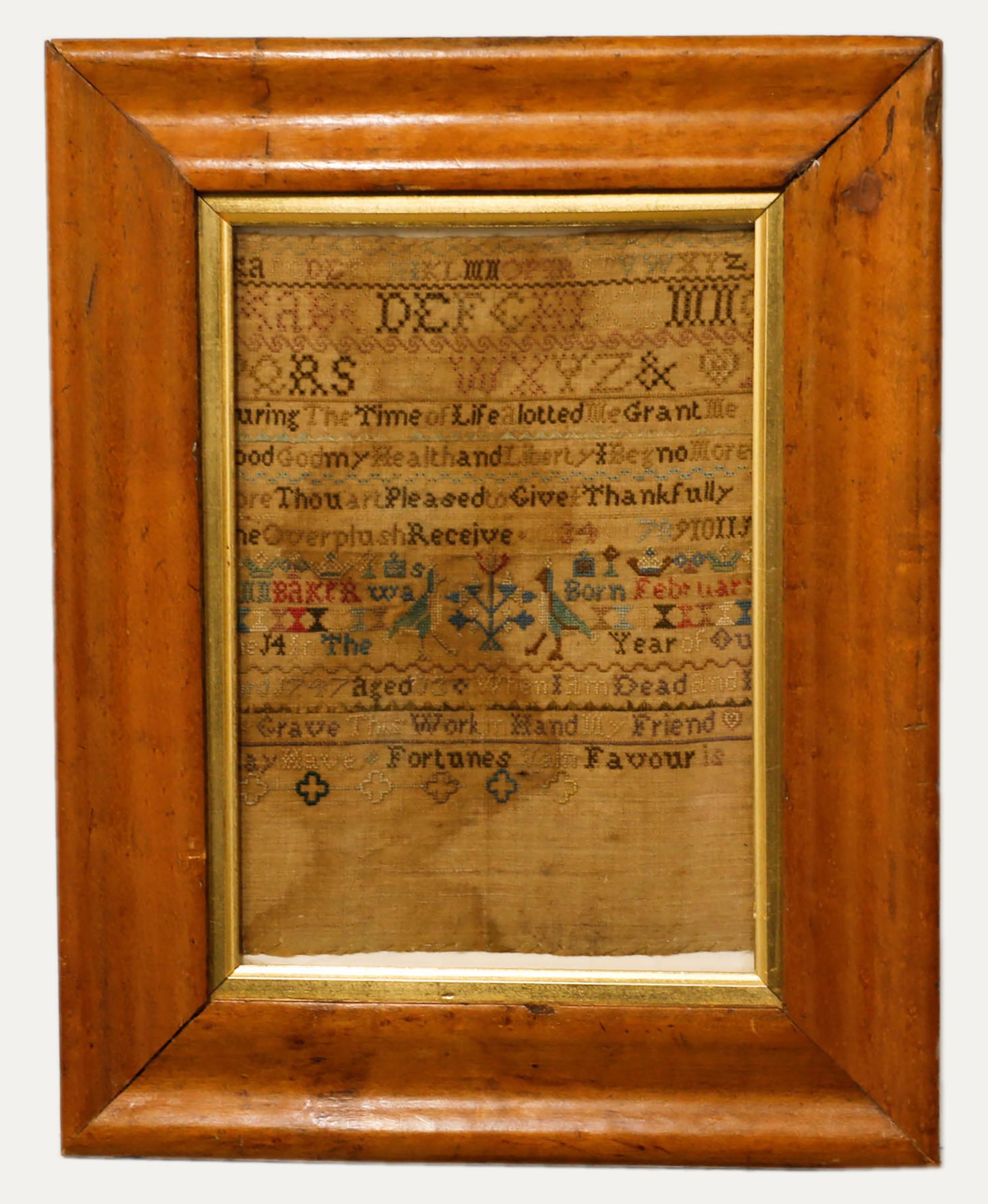 Un encantador muestrario de Jorge II, bordado a mano por Ann Baker en 1747, a la edad de 13 años. El muestrario representa numerosos alfabetos sobre un verso moralista y una pareja de pájaros junto a un árbol. Bien presentado en un hermoso marco de
