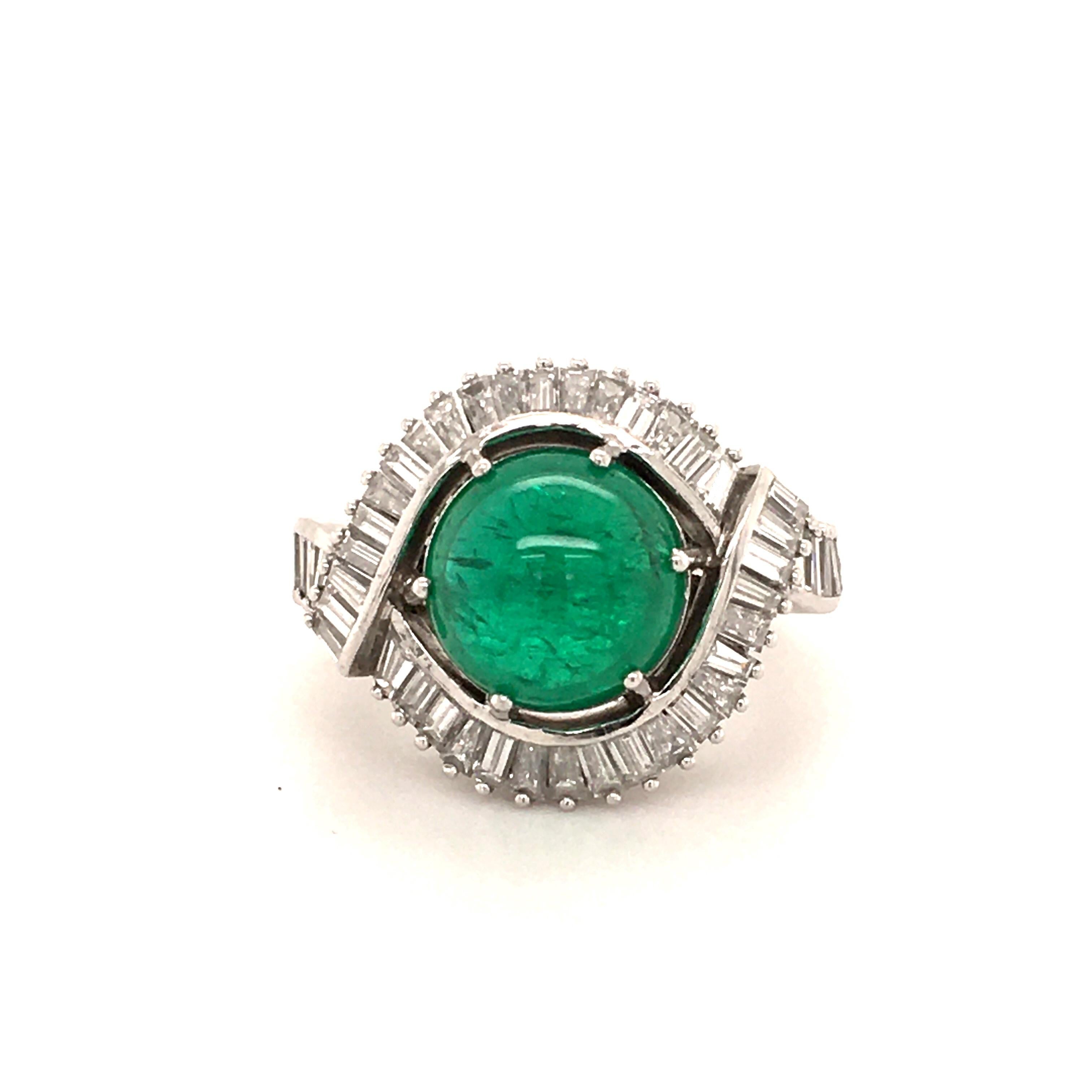 This elegant ring in platinum 950 features a beautiful Colombian cabochon cut emerald of 5.69 carats. Surrounded by two curved lines set with 46 baguette shaped diamonds of H/I colour and vvs/vs clarity, total weight approximately 2.50 carats.

Ring