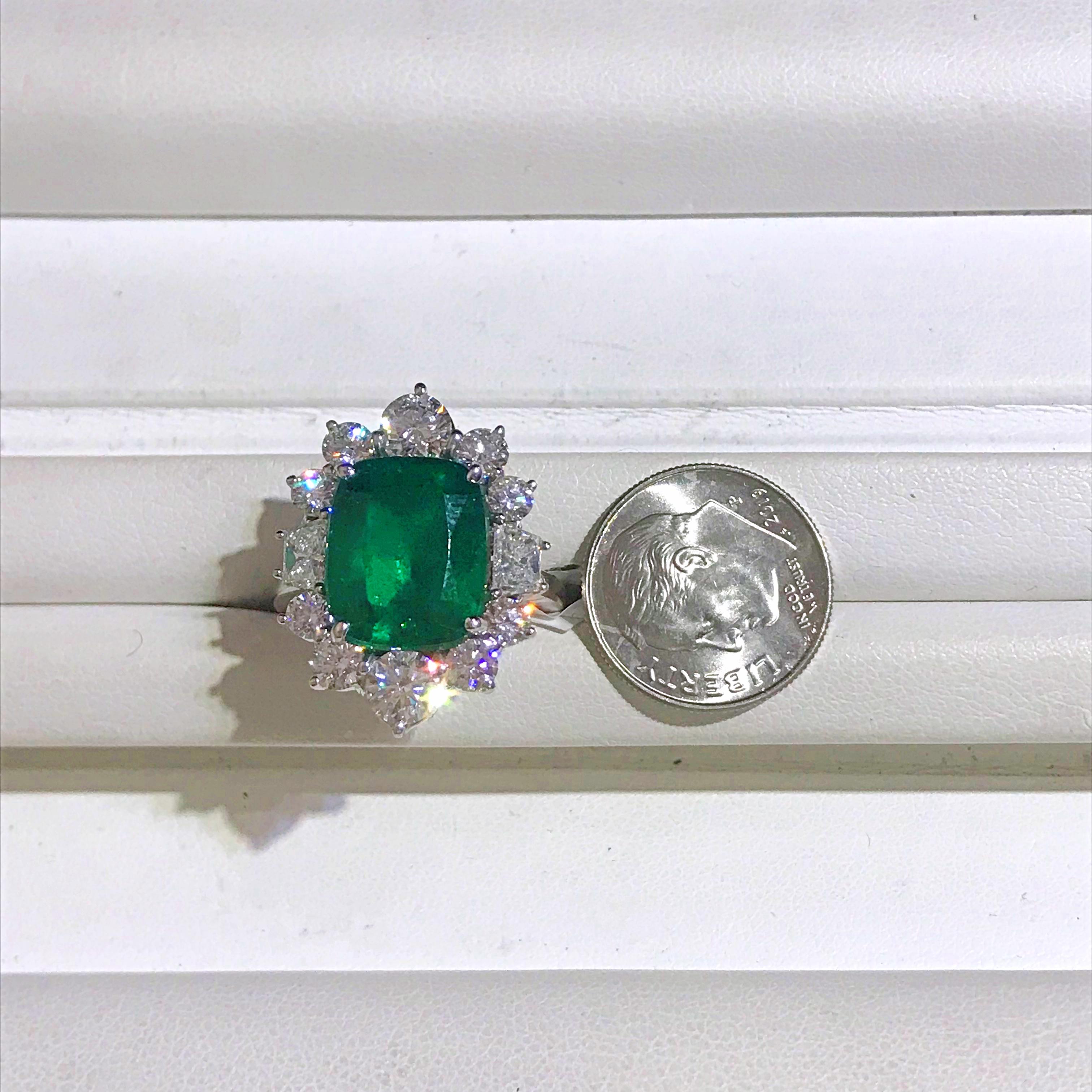 This rich colored Emerald weighs 5.69 carats and is surrounded by an elegant halo of 12 Diamonds totaling 2.60 carats. The ring is crafted from Platinum and currently a size 6.75. This ring is sizeable. Please let us know if we can help or answer